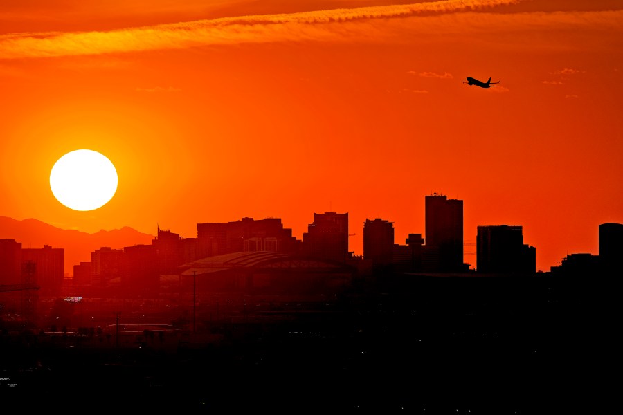 FILE - A jet takes flight from Sky Harbor International Airport as the sun sets over downtown Phoenix, Wednesday, July 12, 2023. (AP Photo/Matt York, File)