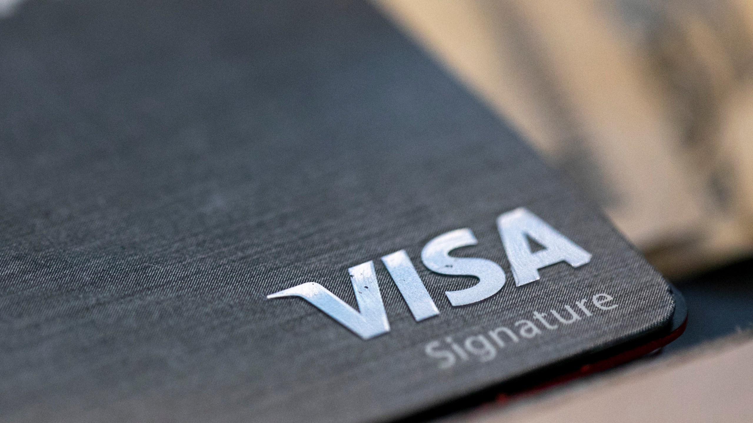 FILE-This Aug. 11, 2019, file photo shows a Visa logo on a credit card in New Orleans. Visa reports earnings on Tuesday July 25, 2023. (AP Photo/Jenny Kane, File)