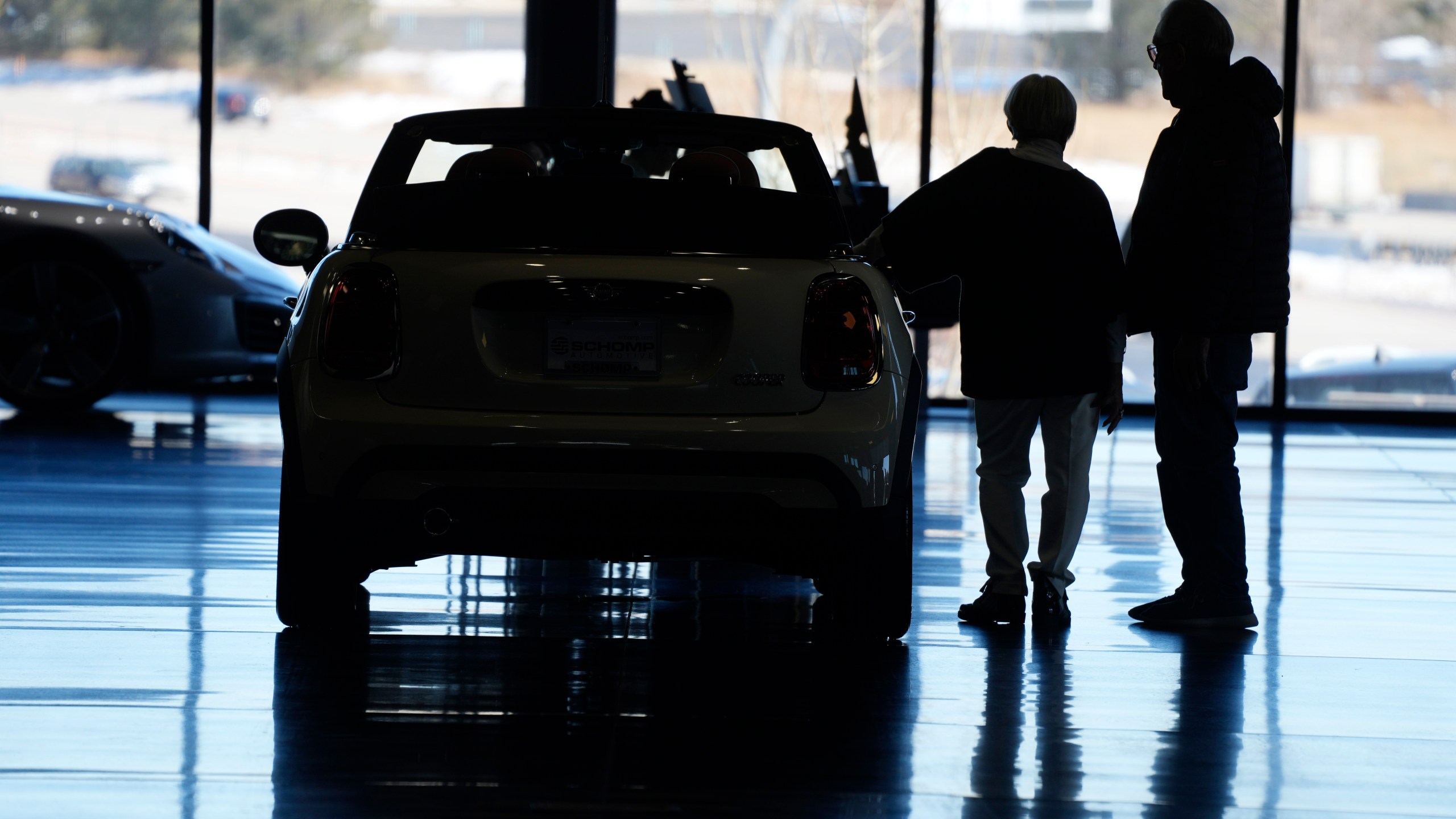 FILE - Shoppers consider a 2022 Cooper convertible on display in a Mini dealership in Highlands Ranch, Colo., on Friday, Feb. 18, 2022. The Federal Reserve’s expected move Wednesday, July 26, 2023, to raise interest rates for the 11th time could once again send ripple effects across the economy. (AP Photo/David Zalubowski)