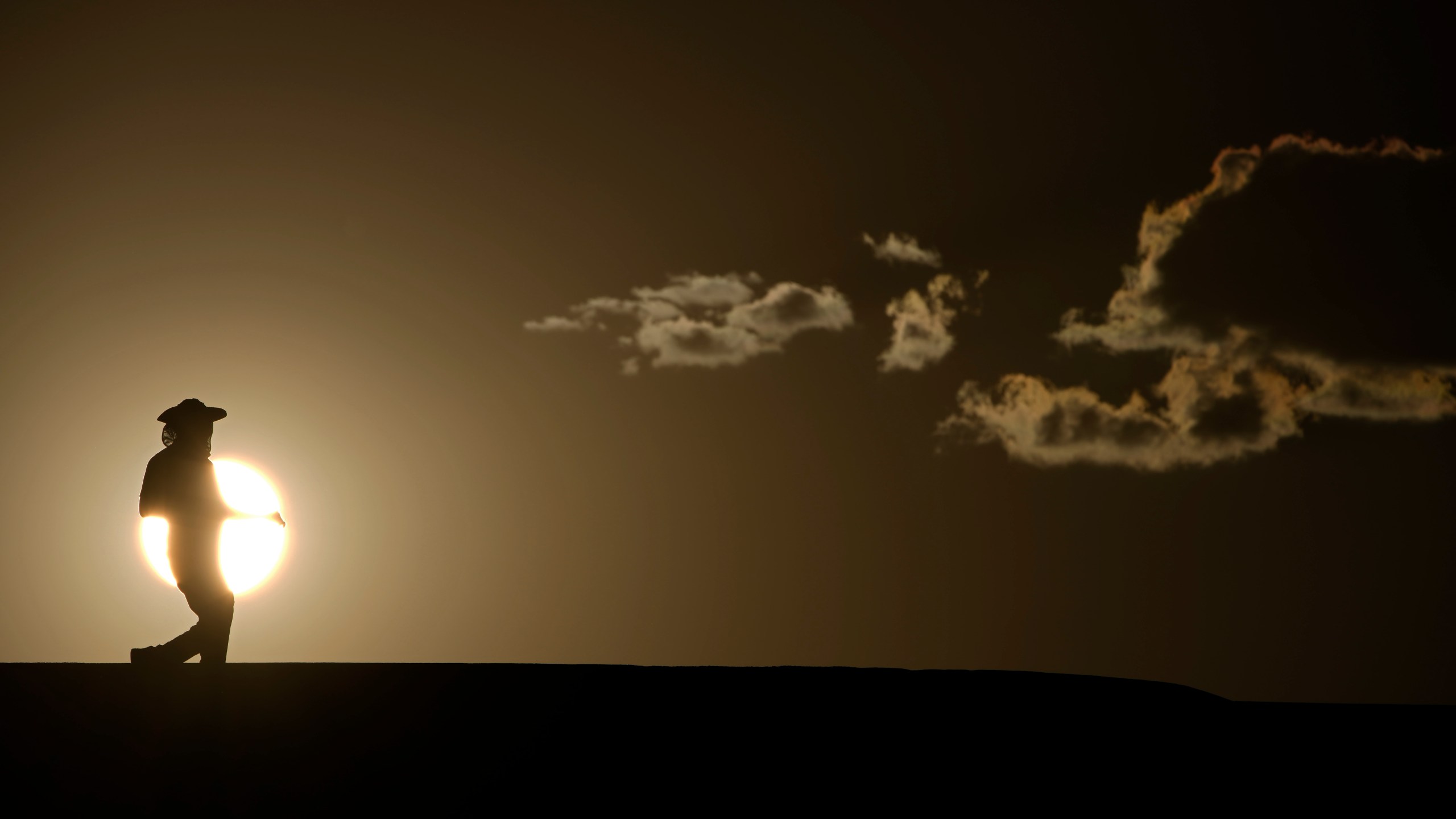 FILE - A person walks along a trail as the sun sets, Sunday, July 16, 2023, in Death Valley National Park, Calif. Human-caused global warming made July hotter for four out of five people on Earth, according to a new report issued Wednesday, Aug. 2, 2023, by Climate Central. (AP Photo/John Locher, File)