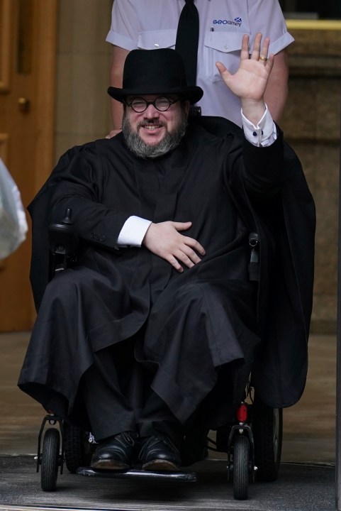 Nicholas Rossi from he U.S. waves as he leaves the Edinburgh Sheriff and Justice of the Peace Court in Edinburgh, Scotland, Wednesday, July 12, 2023. An American fugitive accused of faking his own death to avoid a rape charge has been ordered by a judge in Scotland to be returned to the U.S. The man known as Nicholas Rossi was ordered extradited Wednesday after fighting the case for nearly two years. (Andrew Milligan/PA via AP)