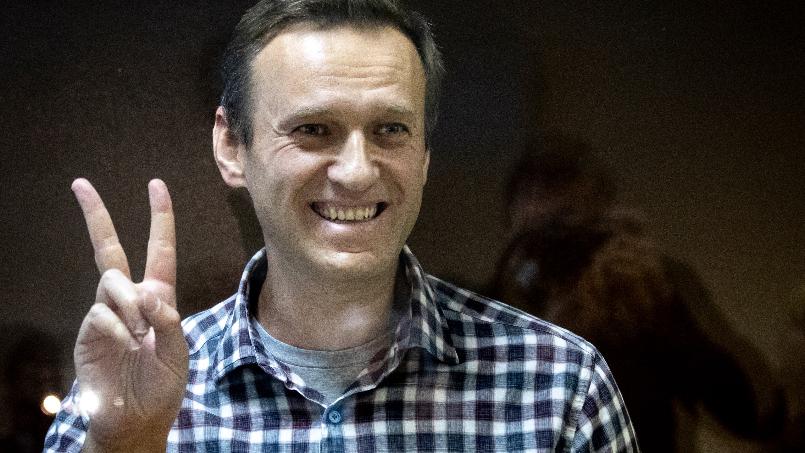 FILE - Russian opposition leader Alexei Navalny gestures as he stands behind a glass panel of a cage in the Babuskinsky District Court in Moscow, Russia, on Feb. 20, 2021. Navalny is due to hear the verdict Friday Aug. 4, 2023 in his latest trial on extremism charges. The prosecution has demanded a 20-year prison sentence, and the politician himself said he expects a lengthy prison term. (AP Photo/Alexander Zemlianichenko, File)