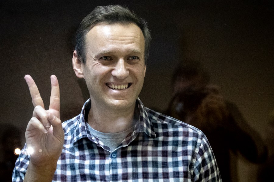 FILE - Russian opposition leader Alexei Navalny gestures as he stands behind a glass panel of a cage in the Babuskinsky District Court in Moscow, Russia, on Feb. 20, 2021. Navalny is due to hear the verdict Friday Aug. 4, 2023 in his latest trial on extremism charges. The prosecution has demanded a 20-year prison sentence, and the politician himself said he expects a lengthy prison term. (AP Photo/Alexander Zemlianichenko, File)