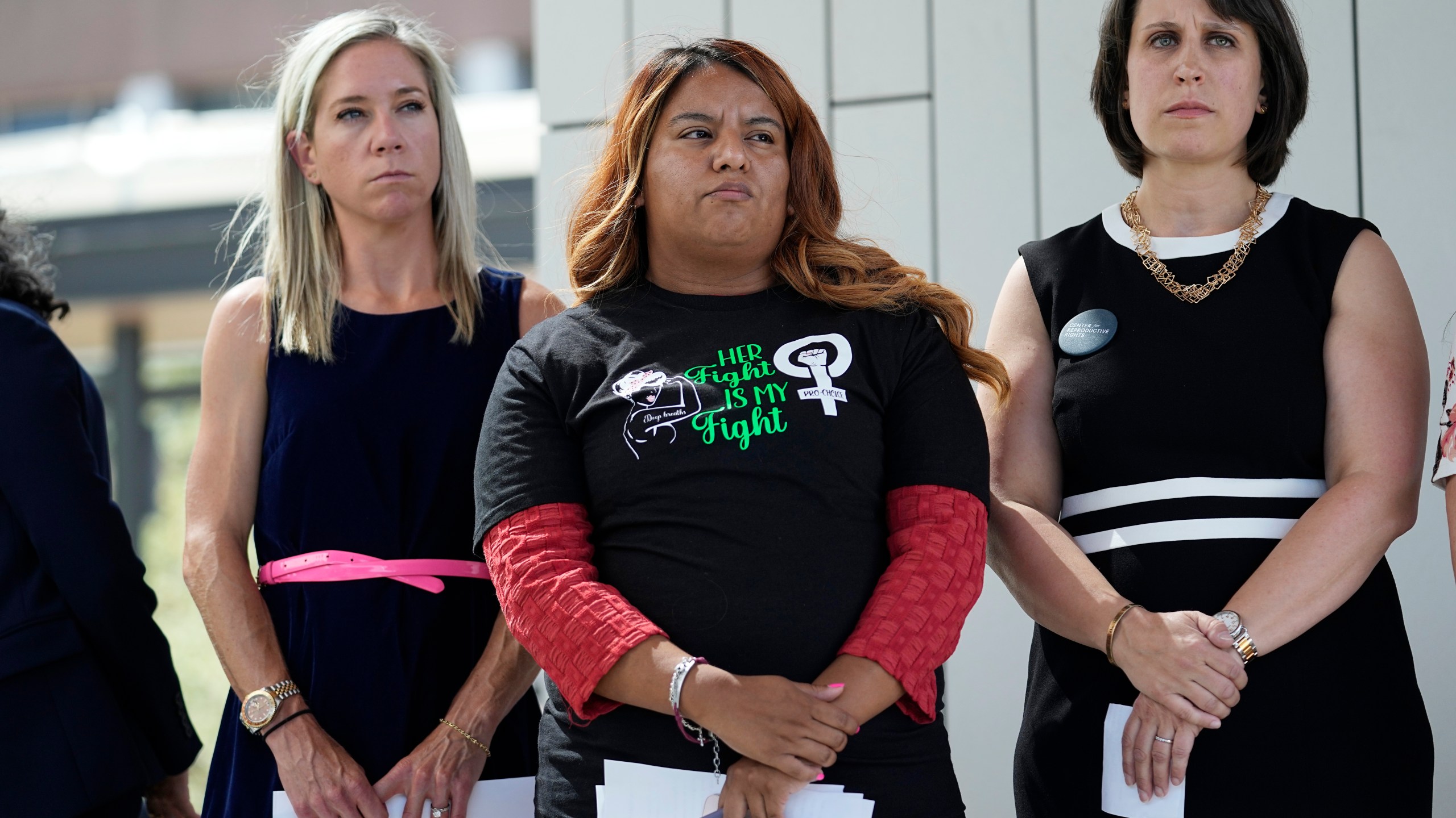 FILE - Amanda Zurawski, who developed sepsis and nearly died after being refused an abortion when her water broke at 18 weeks, left, and Samantha Casiano, who was forced to carry a nonviable pregnancy to term and give birth to a baby who died four hours after birth, center, stand with their attorney Molly Duane outside the Travis County Courthouse, Wednesday, July 19, 2023, in Austin, Texas. A Texas judge ruled Friday, Aug. 4, 2023, the state’s abortion ban has proven too restrictive for women with serious pregnancy complications and must allow exceptions without doctors fearing the threat of criminal charges. The challenge is believed to be the first in the U.S. brought by women who have been denied abortions since the Supreme Court last year overturned Roe v. Wade, which for nearly 50 years had affirmed the constitutional right to an abortion. (AP Photo/Eric Gay, File)