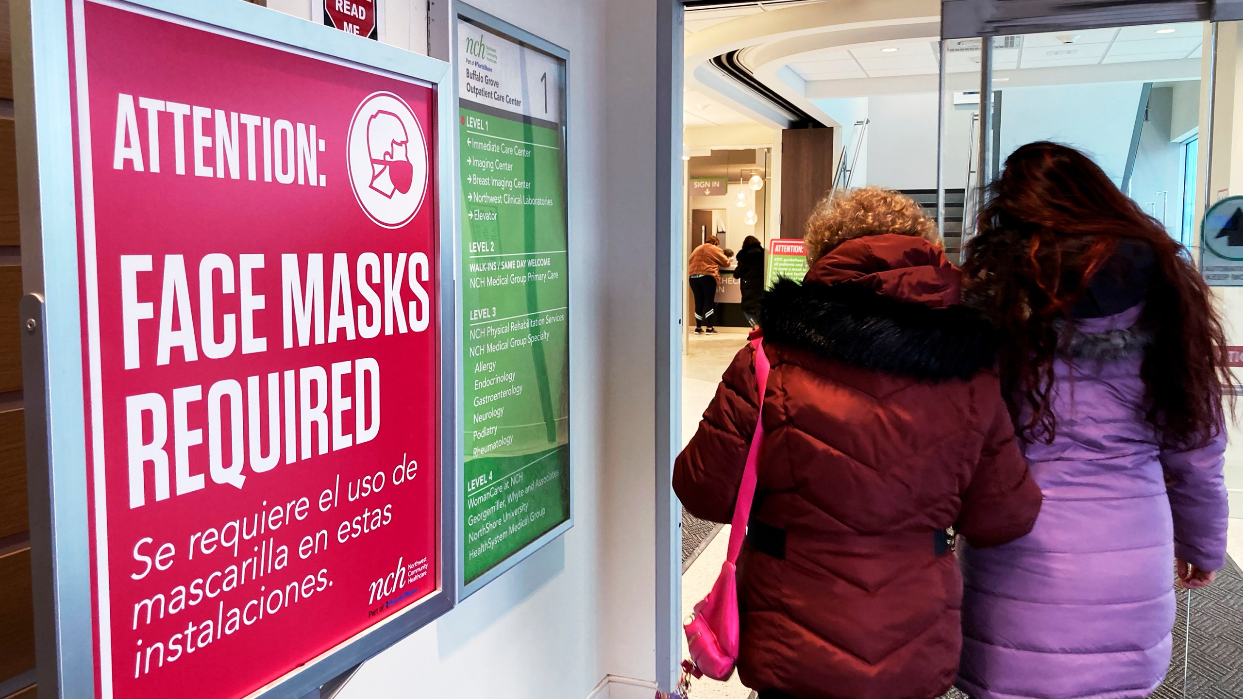 A sign announcing a face mask requirement is displayed at a hospital in Buffalo Grove, Ill., Friday, Jan. 13, 2023. COVID-19 hospital admissions are inching upward in the United States since early July 2023. It's a small-scale echo of the three previous summers. (AP Photo/Nam Y. Huh)