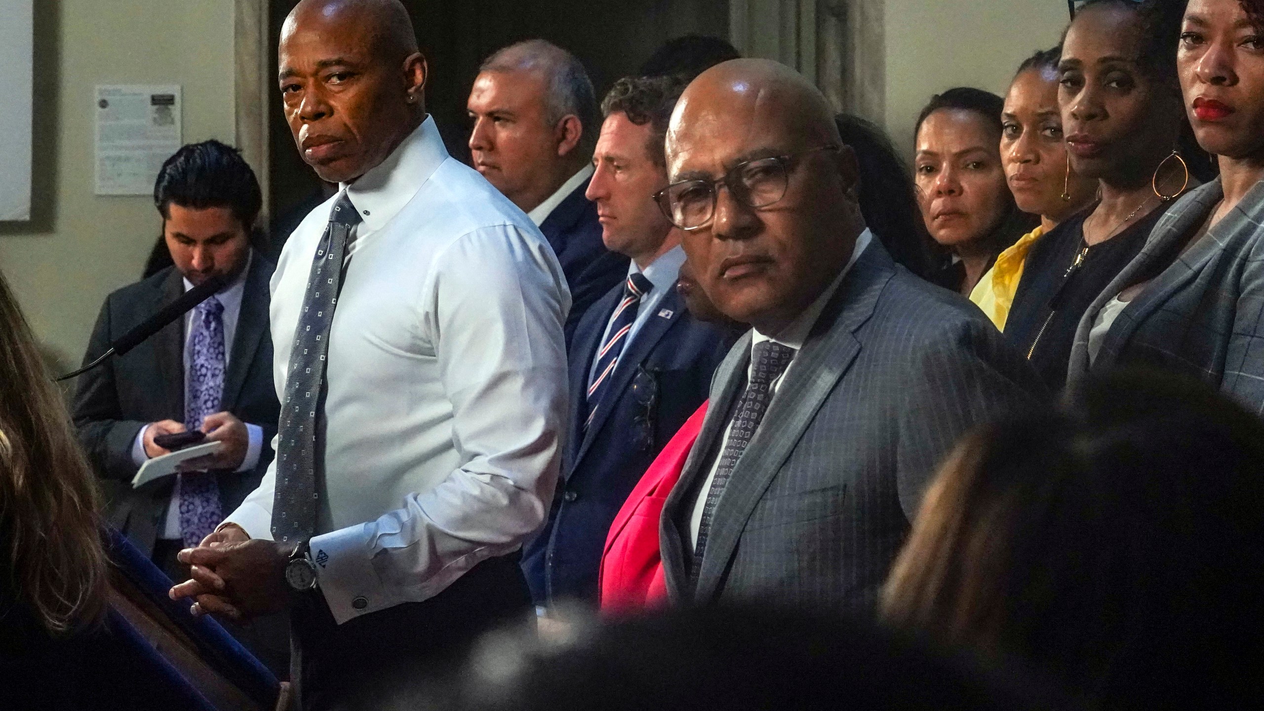 New York Mayor Eric Adams, left, and city officials listen to a reporter's question during a City Hall press conference, Wednesday Aug. 9, 2023, in New York. Adams is calling on the federal government to declare a national emergency to ease the financial crisis the city is facing as it struggles to accommodate thousands of arriving migrants. (AP Photo/Bebeto Matthews)