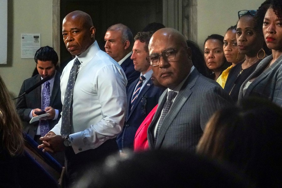 New York Mayor Eric Adams, left, and city officials listen to a reporter's question during a City Hall press conference, Wednesday Aug. 9, 2023, in New York. Adams is calling on the federal government to declare a national emergency to ease the financial crisis the city is facing as it struggles to accommodate thousands of arriving migrants. (AP Photo/Bebeto Matthews)