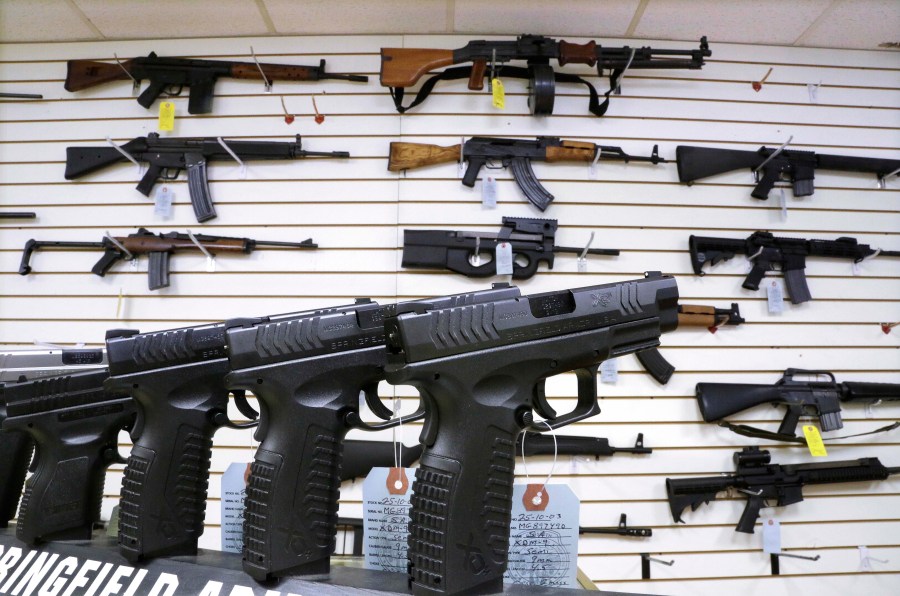 FILE - Assault weapons and hand guns are seen for sale at Capitol City Arms Supply on Jan. 16, 2013, in Springfield, Ill. The Illinois Supreme Court will issue an opinion on the state's ban on the sale or possession of semi-automatic weapons of the type used in the 2022 Independence Day shooting in the Chicago suburb of Highland Park that killed seven and dozens of other mass shootings nationally. Rep. Dan Caulkins, a Decatur Republican, and other gun owners of Macon County filed the lawsuit contending the law not only violates the Second Amendment but equal protection of the laws because it exempts police and military from the ban. (AP Photo/Seth Perlman, File)