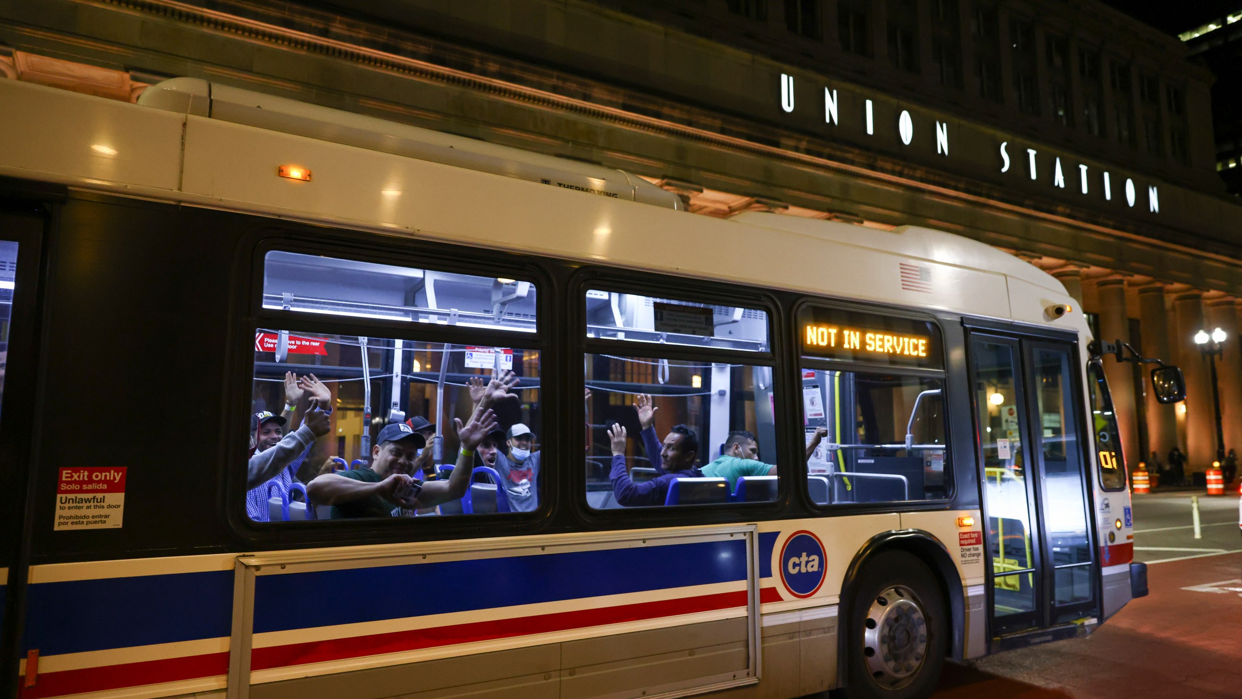 FILE -Migrants wave as a bus leaves to take them to a refugee center outside Union Station in Chicago, Wednesday, Aug. 31, 2022. Authorities say a 3-year-old child riding one of Texas’ migrant buses died while on the way to Chicago. Texas authorities confirmed a child’s death in a statement Friday, Aug. 11, 2023 that did not say where the child was from or why they became ill. (Anthony Vazquez/Chicago Sun-Times via AP)