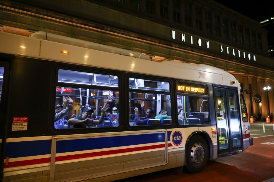 FILE -Migrants wave as a bus leaves to take them to a refugee center outside Union Station in Chicago, Wednesday, Aug. 31, 2022. Authorities say a 3-year-old child riding one of Texas’ migrant buses died while on the way to Chicago. Texas authorities confirmed a child’s death in a statement Friday, Aug. 11, 2023 that did not say where the child was from or why they became ill. (Anthony Vazquez/Chicago Sun-Times via AP)