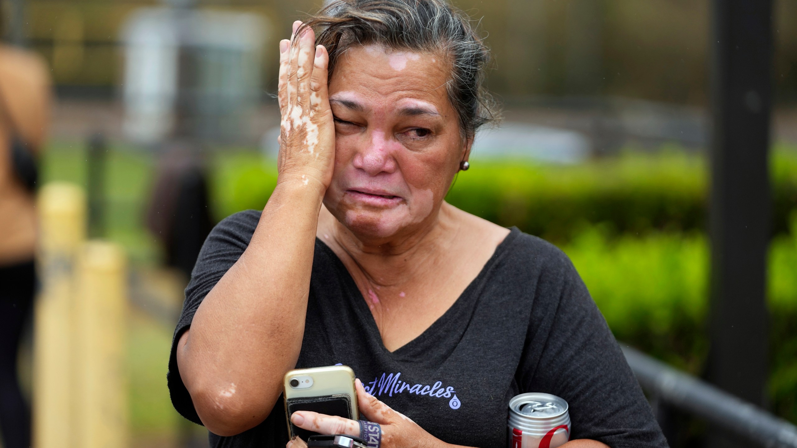 Myrna Ah Hee reacts as she waits in front of an evacuation center at the War Memorial Gymnasium, Thursday, Aug. 10, 2023, in Wailuku, Hawaii. The Ah Hees were there because they were looking for her husband's brother. Their own home in Lahaina was spared, but the homes of many of their relatives were destroyed by wildfires. (AP Photo/Rick Bowmer)