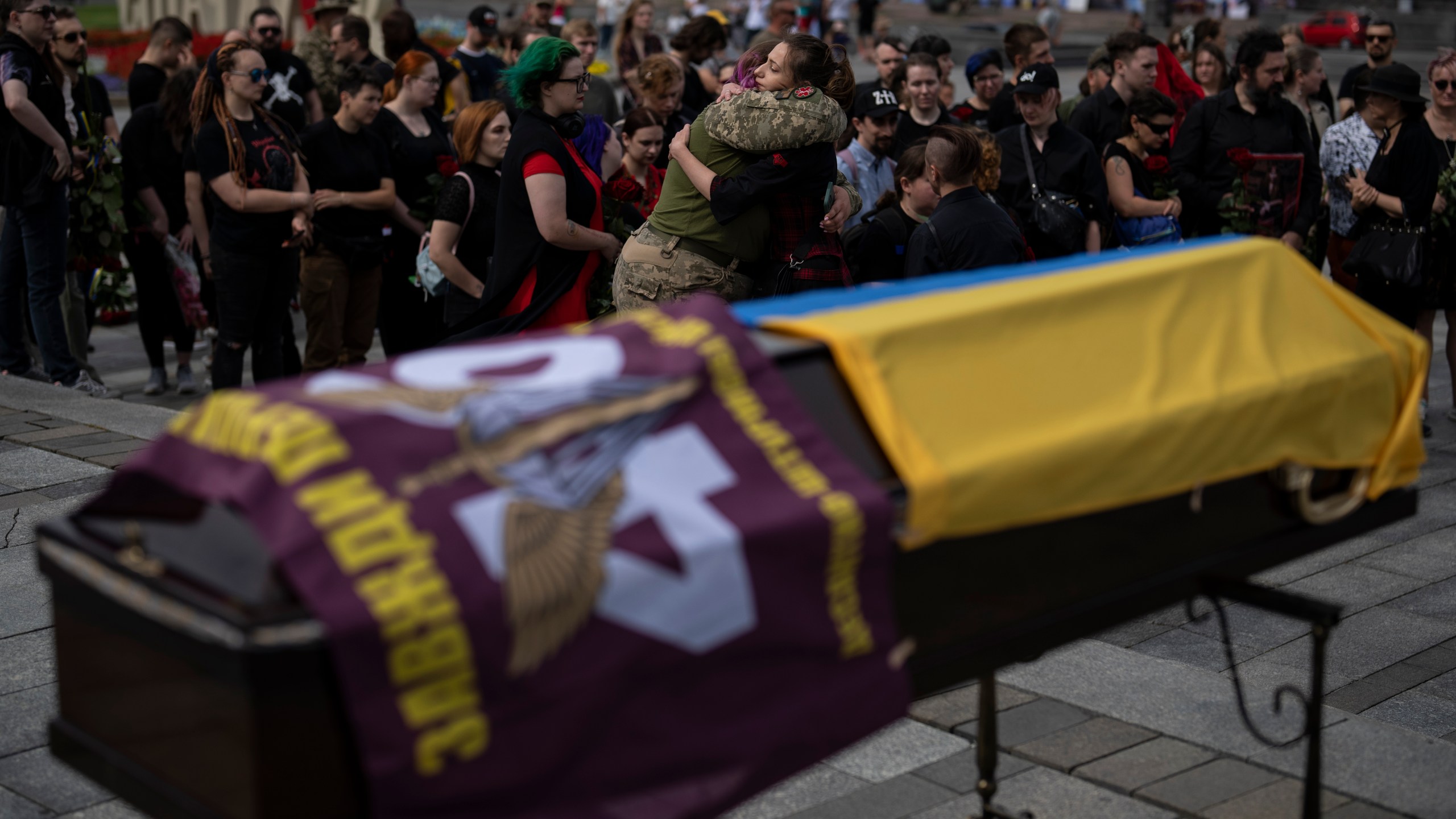 Friends of Daria Filipova, 34, hug each other at her funeral ceremony in Kyiv, Ukraine, Saturday, Aug. 12, 2023. Filipova was a medic in the Ukrainian army and died in an attack in the Donetsk region. (AP Photo/Bram Janssen)