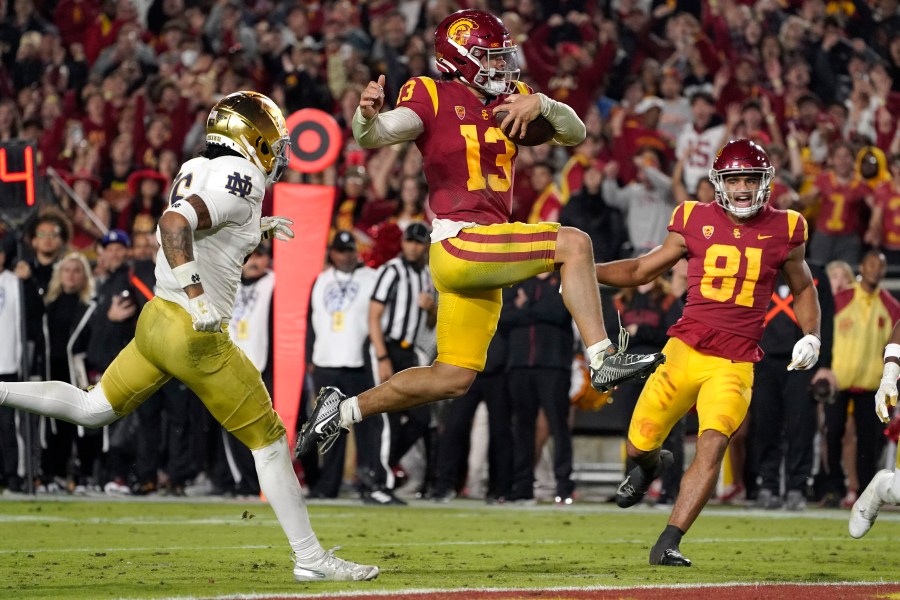 FILE - Southern California quarterback Caleb Williams jumps in for a touchdown as Notre Dame safety Xavier Watts, left, defends and Southern California wide receiver Kyle Ford watch during the second half of an NCAA college football game Saturday, Nov. 26, 2022, in Los Angeles. Caleb Williams was named to The Associated Press preseason All-America team, Monday, Aug. 21, 2023. (AP Photo/Mark J. Terrill, File)