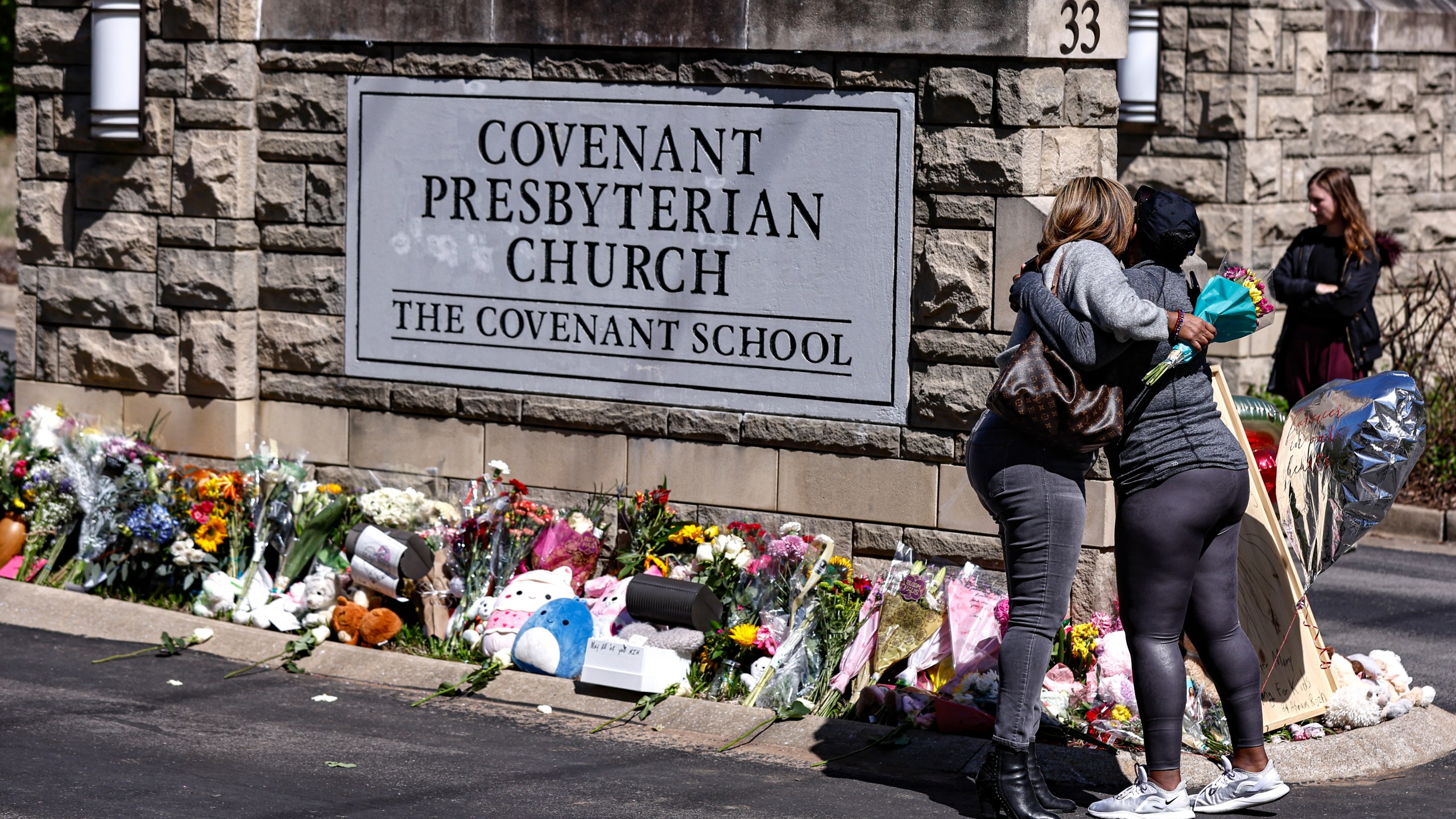 FILE - Two women hug at a memorial at the entrance to The Covenant School on Wednesday, March 29, 2023, in Nashville, Tenn. Tennessee Gov. Bill Lee on Tuesday, Aug. 8, 2023 unveiled a sweeping list of public safety issues he wants lawmakers to address during an upcoming special session prompted by a shocking Nashville school shooting earlier this year that resulted in the deaths of three children and three adults. (AP Photo/Wade Payne, File)