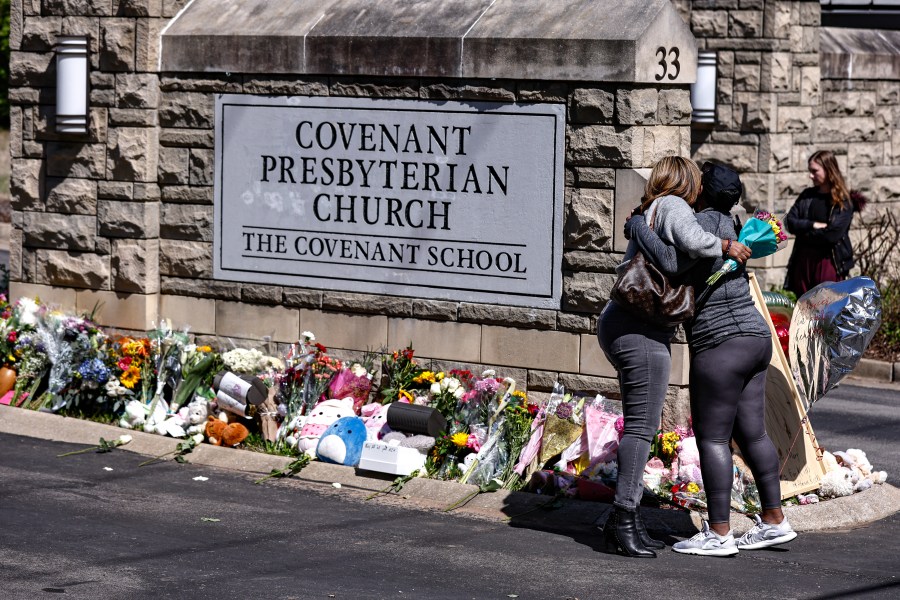 FILE - Two women hug at a memorial at the entrance to The Covenant School on Wednesday, March 29, 2023, in Nashville, Tenn. Tennessee Gov. Bill Lee on Tuesday, Aug. 8, 2023 unveiled a sweeping list of public safety issues he wants lawmakers to address during an upcoming special session prompted by a shocking Nashville school shooting earlier this year that resulted in the deaths of three children and three adults. (AP Photo/Wade Payne, File)