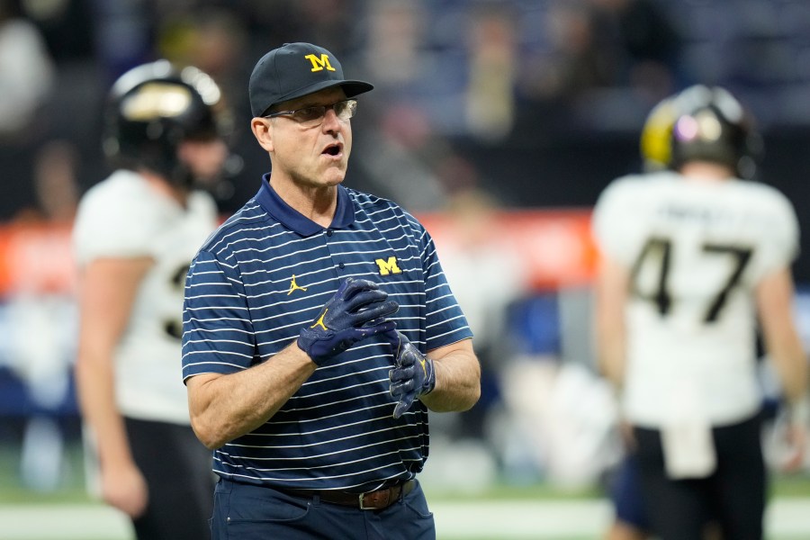 FILE - Michigan head coach Jim Harbaugh watches before the start of the Big Ten championship NCAA college football game against Purdue, Saturday, Dec. 3, 2022, in Indianapolis. Michigan coach Jim Harbaugh has informed his team and staff that he will serve a three-game suspension to start this season as part of the school’s self-imposed penalties for NCAA infractions, two people familiar with the situation told The Associated Press on Monday, Aug. 21, 2023. (AP Photo/AJ Mast, File)