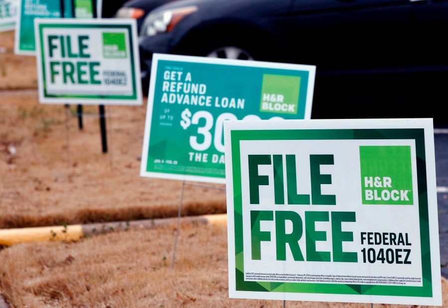 FILE- In this Feb. 14, 2018, file photo, H&R Block signs are displayed in Jackson, Miss. Congressional Democrats are accusing big tax preparation firms including Intuit and H&R Block of undermining the federal government's upcoming electronic free-file tax return system, and are demanding lobbying, hiring and revenue data to determine what's going on. (AP Photo/Rogelio V. Solis, File)