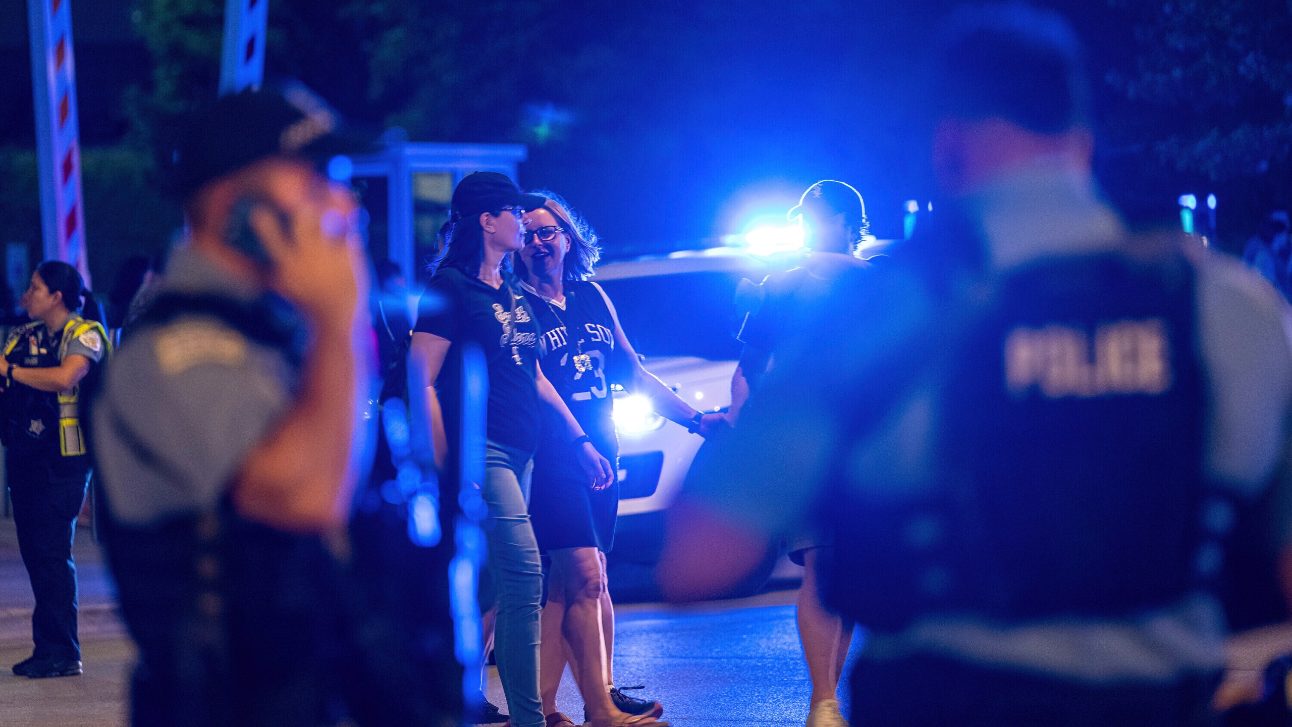 People pass by Chicago police officers outside Guaranteed Rate Field on Friday, Aug. 25, 2023, in Chicago. Police are investigating a shooting at a White Sox baseball game at the stadium Friday night. Police said the investigation is ongoing. Additional details were expected to be released later. (Tyler Pasciak LaRiviere/Chicago Sun-Times via AP)