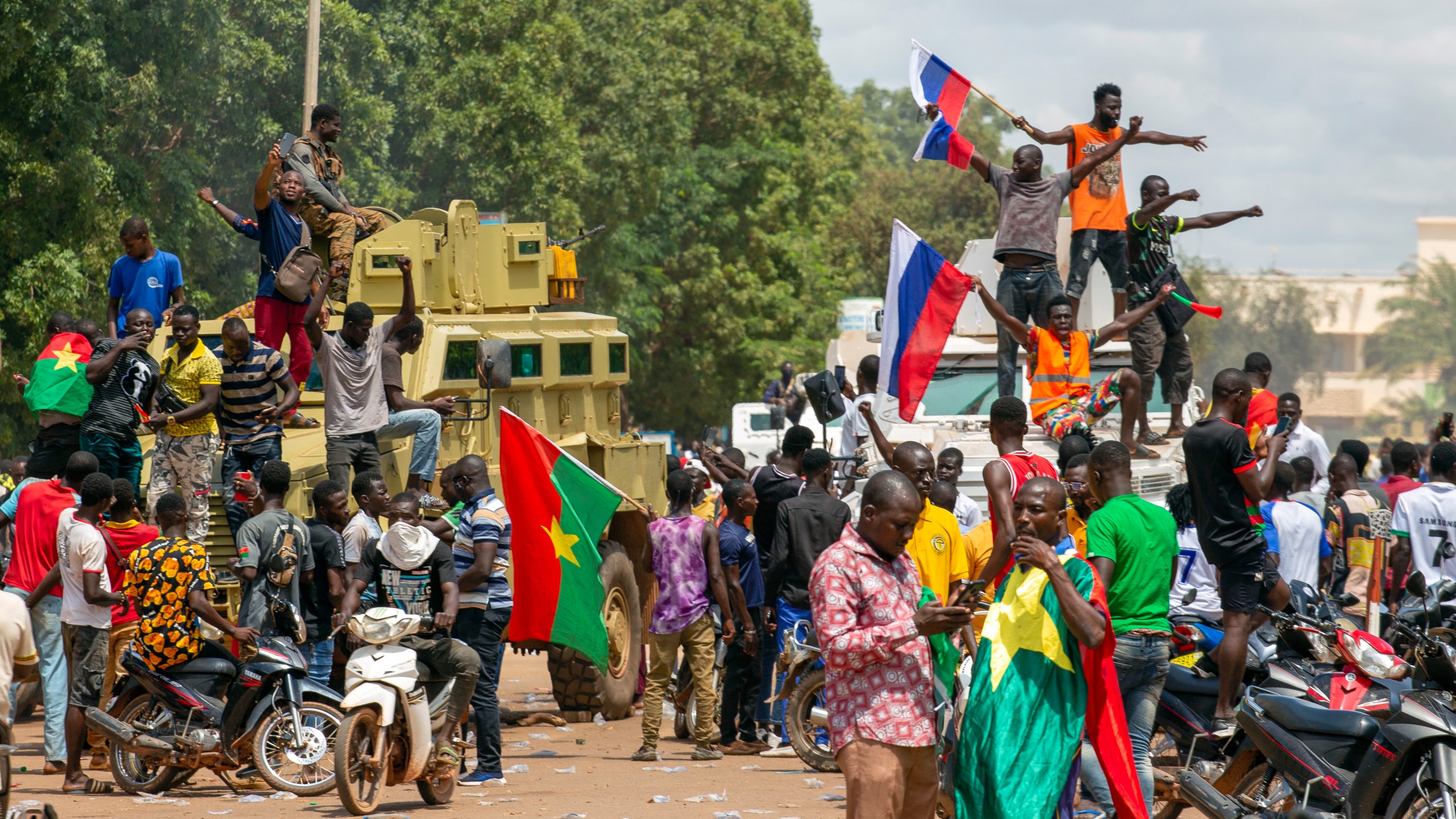 Supporters of Capt. Ibrahim Traore cheer with Russian flags in the streets of Ouagadougou, Burkina Faso, Sunday, Oct. 2, 2022. Russia's Wagner Group, a private military company led by Yevgeny Prigozhin, has played a key role in the fighting in Ukraine and also deployed its personnel to Syria, Libya and several African countries. Prigozhin's presumed death in a plane crash along with some of his top lieutenants raises doubts about the future of the military contractor. (AP Photo/Kilaye Bationo)