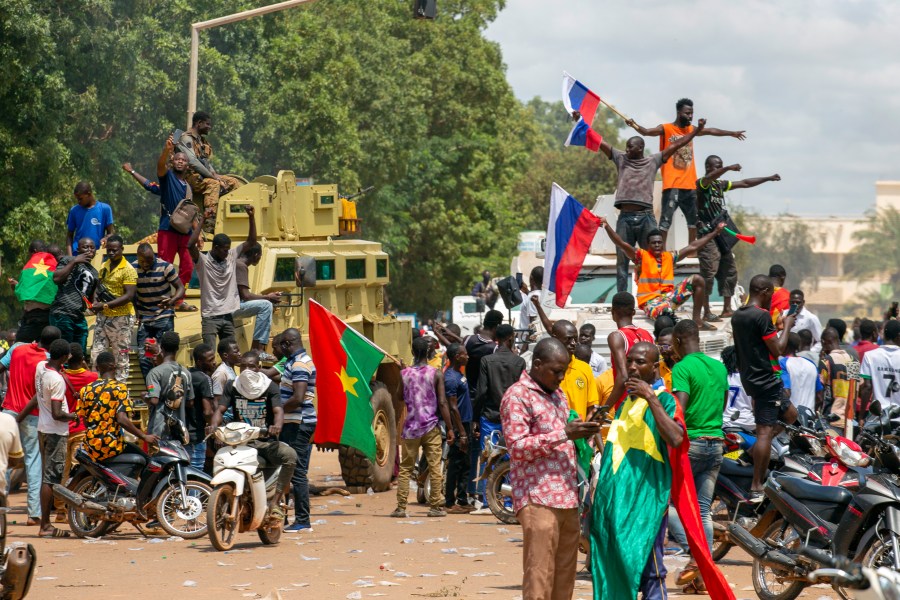 Supporters of Capt. Ibrahim Traore cheer with Russian flags in the streets of Ouagadougou, Burkina Faso, Sunday, Oct. 2, 2022. Russia's Wagner Group, a private military company led by Yevgeny Prigozhin, has played a key role in the fighting in Ukraine and also deployed its personnel to Syria, Libya and several African countries. Prigozhin's presumed death in a plane crash along with some of his top lieutenants raises doubts about the future of the military contractor. (AP Photo/Kilaye Bationo)