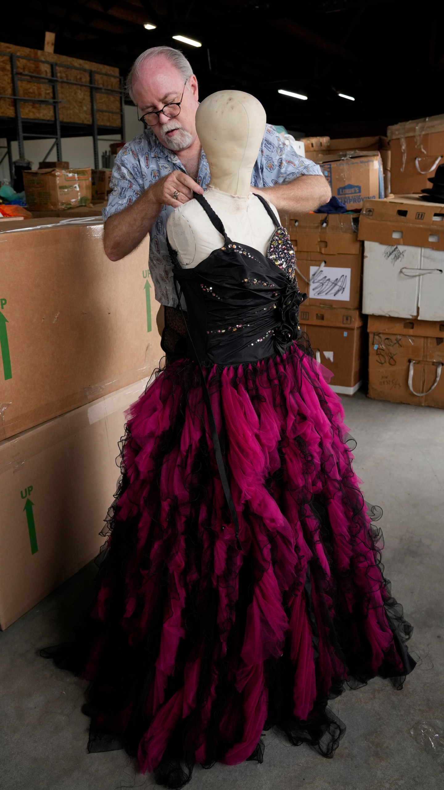 Shon LeBlanc, co-owner of costume rental service Valentino's Costume Group, primps a popular dress item, Friday, May 26, 2023, at his warehouse in Los Angeles. (AP Photo/Chris Pizzello)