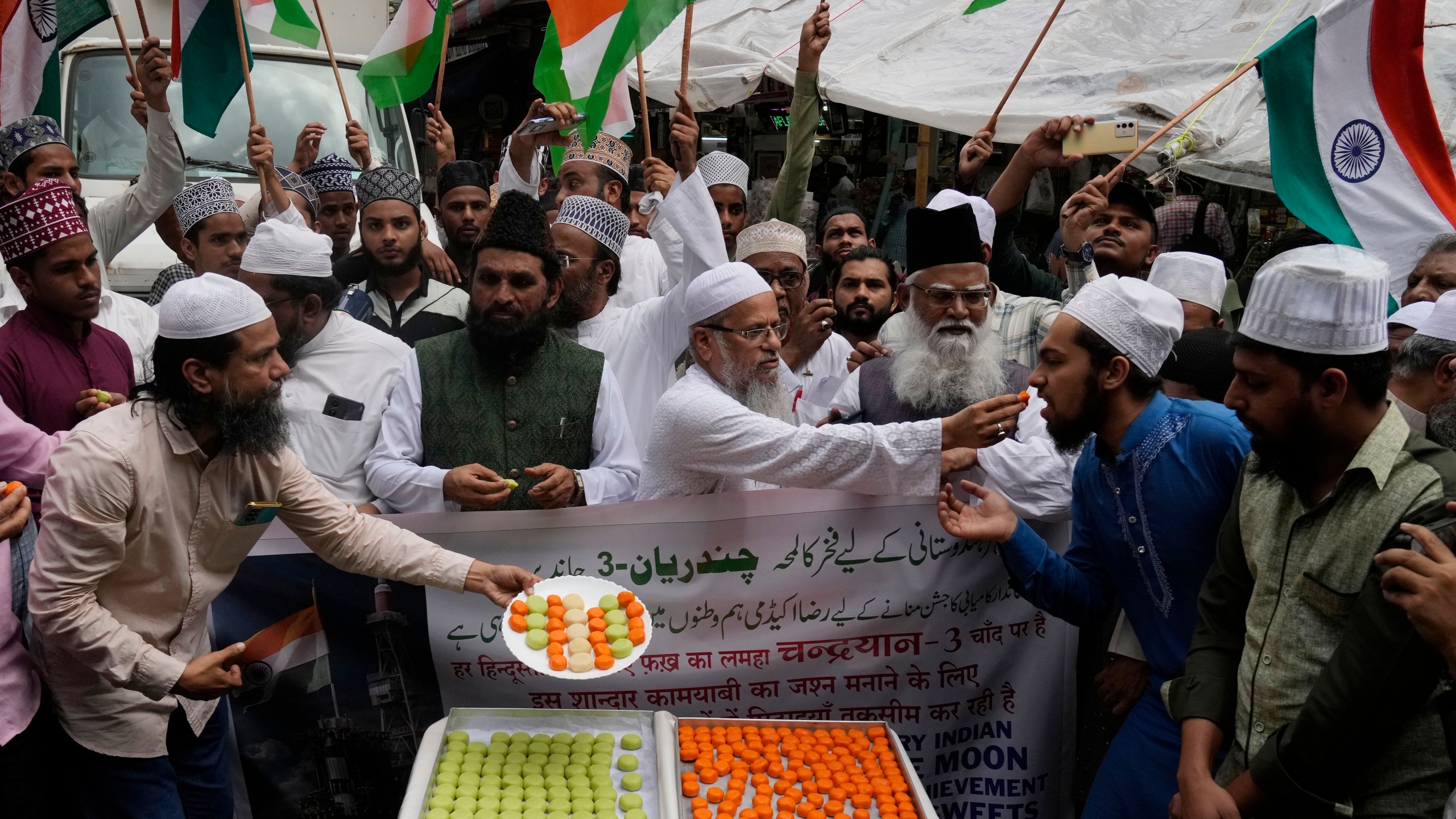 Indians distribute sweets to celebrate the success of Chandrayaan - 3 soft landing on the moon, in Mumbai, India, Wednesday, Aug. 23, 2023.(AP Photo/Rajanish Kakade)