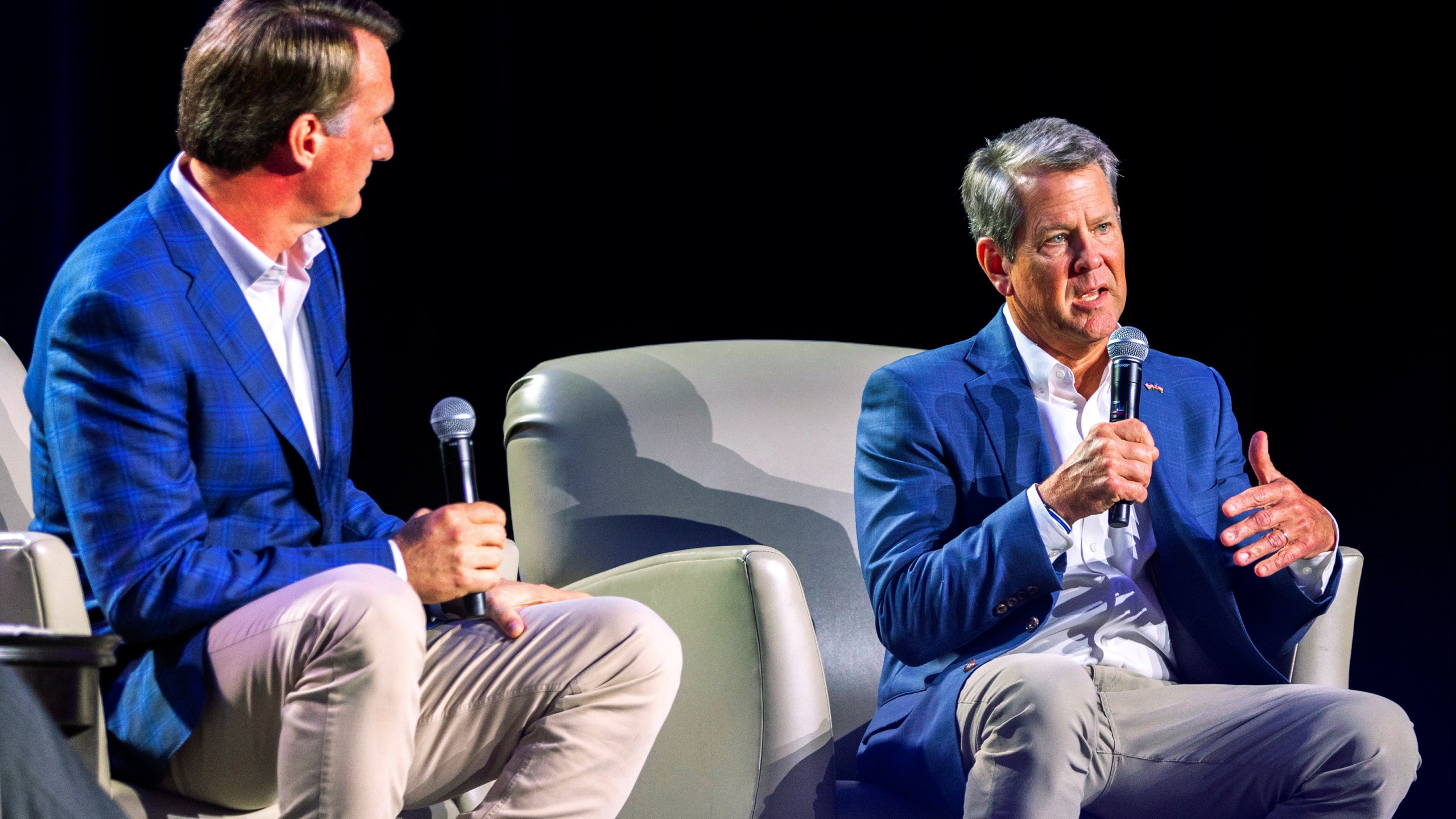 FILE - Virginia Gov. Glenn Youngkin, left, and Georgia Gov. Brian Kemp speak at The Gathering conservative political conference, Saturday, Aug. 19, 2023, in the Buckhead area of Atlanta. The Republican Kemp thus far has steered clear of proposals to sanction Fulton County District Attorney Fani Willis, a Democrat, for indicting former President Donald Trump and 18 others. (Arvin Temkar/Atlanta Journal-Constitution via AP, File)