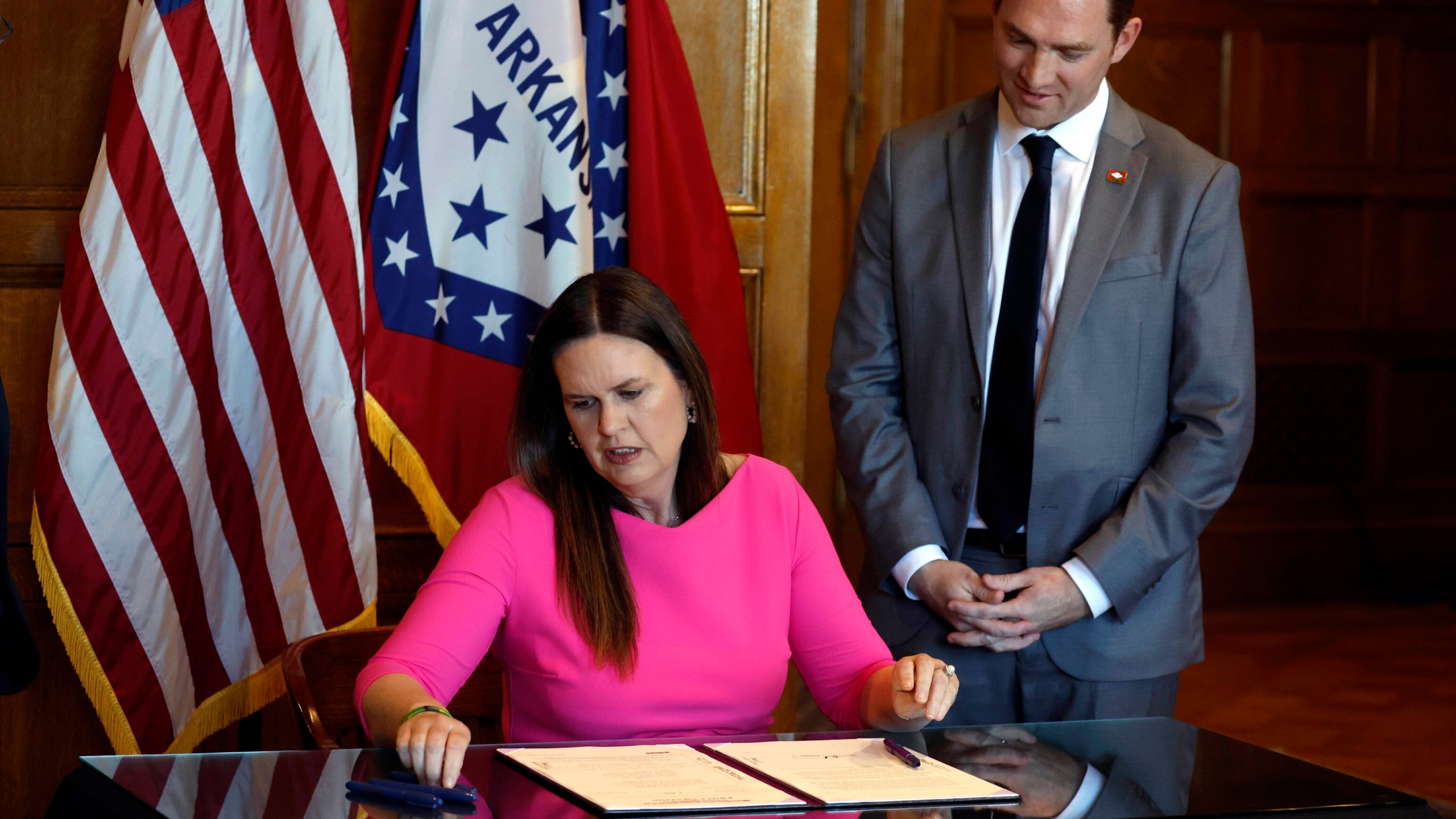 FILE - Arkansas Gov. Sarah Huckabee Sanders signs a bill requiring age verification before creating a new social media account as Sen. Tyler Dees, R-Siloam Springs, looks on during a signing ceremony, Wednesday, April 12, 2023, at the state Capitol in Little Rock, Ark. A federal judge on Thursday, Aug. 31, 2023, temporarily blocked Arkansas from enforcing the new law that would have required parental consent for minors to create new social media accounts, preventing the state from becoming the first to impose such a restriction.(Thomas Metthe/Arkansas Democrat-Gazette via AP, File)