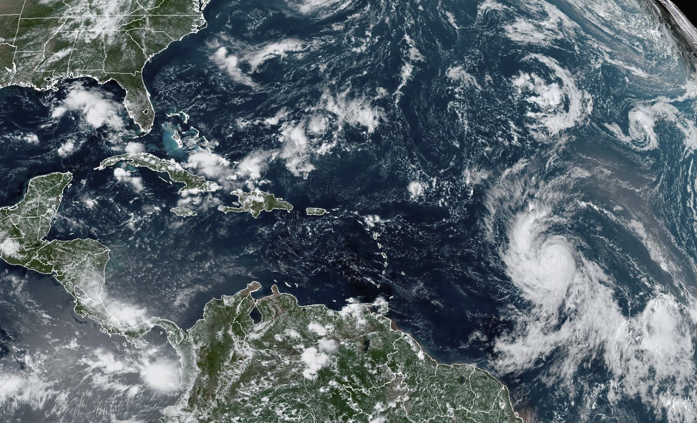 This Wednesday, Sept. 6, 2023, satellite image provided by the National Oceanic and Atmospheric Administration shows Hurricane Lee, right, off in the central tropical Atlantic Ocean. (NOAA via AP)