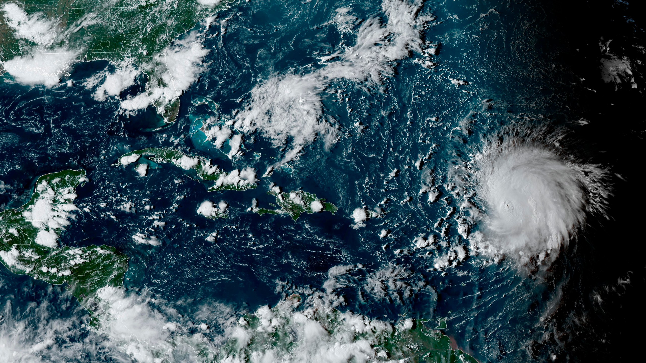 This satellite image provided by the National Oceanographic and Atmospheric Administration shows Hurricane Lee, right, in the Atlantic Ocean on Friday, Sept. 8, 2023, at 4:50 p.m. EDT. Lee is rewriting old rules of meteorology, leaving experts astonished at how rapidly it grew into a goliath Category 5 hurricane. (NOAA via AP)