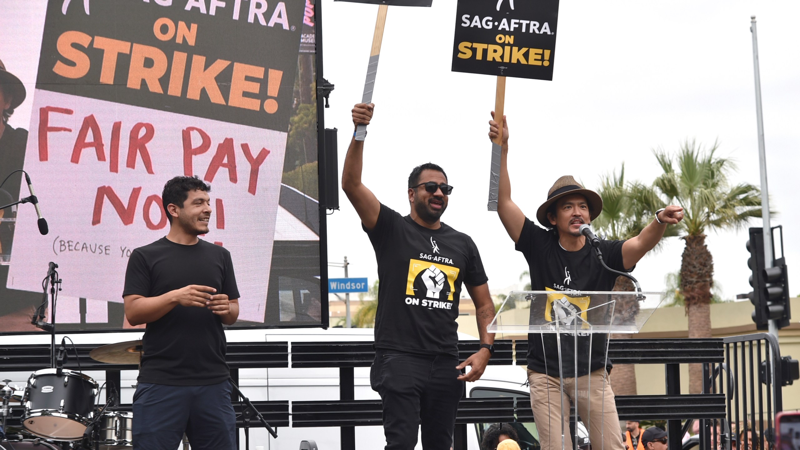 Kal Penn, center, and John Cho, right, speak during a rally outside Paramount Pictures Studio on Wednesday, Sept. 13, 2023, in Los Angeles. The film and television industries remain paralyzed by Hollywood's dual actors and screenwriters strikes. (Photo by Richard Shotwell/Invision/AP)