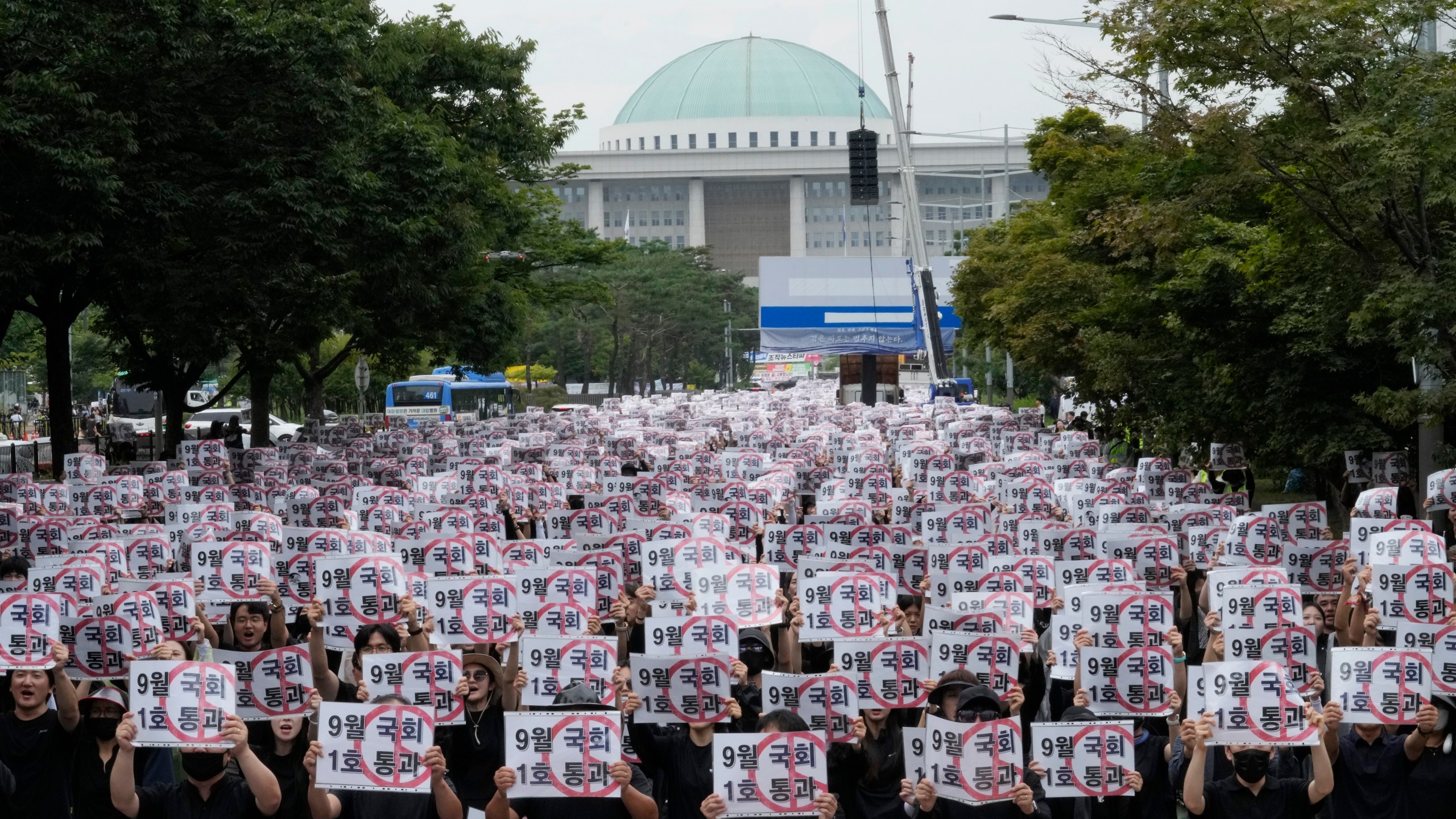 Teachers hold up their banners during a rally to demand the better protection of their rights near the National Assembly in Seoul, South Korea, Saturday, Sept. 16, 2023. Following the suicide of an elementary school teacher in July, teachers across South Korea have been pushing for improved systems to protect teachers from widespread malicious complaints from parents. The signs read "Pass (the teacher rights restoration bills) in September parliament session." (AP Photo/Ahn Young-joon).