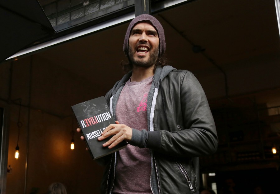 FILE - Russell Brand speaks at the opening of The Trew Era Cafe, a social enterprise community project on the New Era estate in east London, Thursday, 26 March, 2015. Three British news organizations are on Saturday, Sept. 16, 2023 reporting that comedian and social influencer Russell Brand has been accused of rape, sexual assault and abuse based on allegations from four women who knew him over a seven-year period at the height of his fame. (Photo by Joel Ryan/Invision/AP, file)