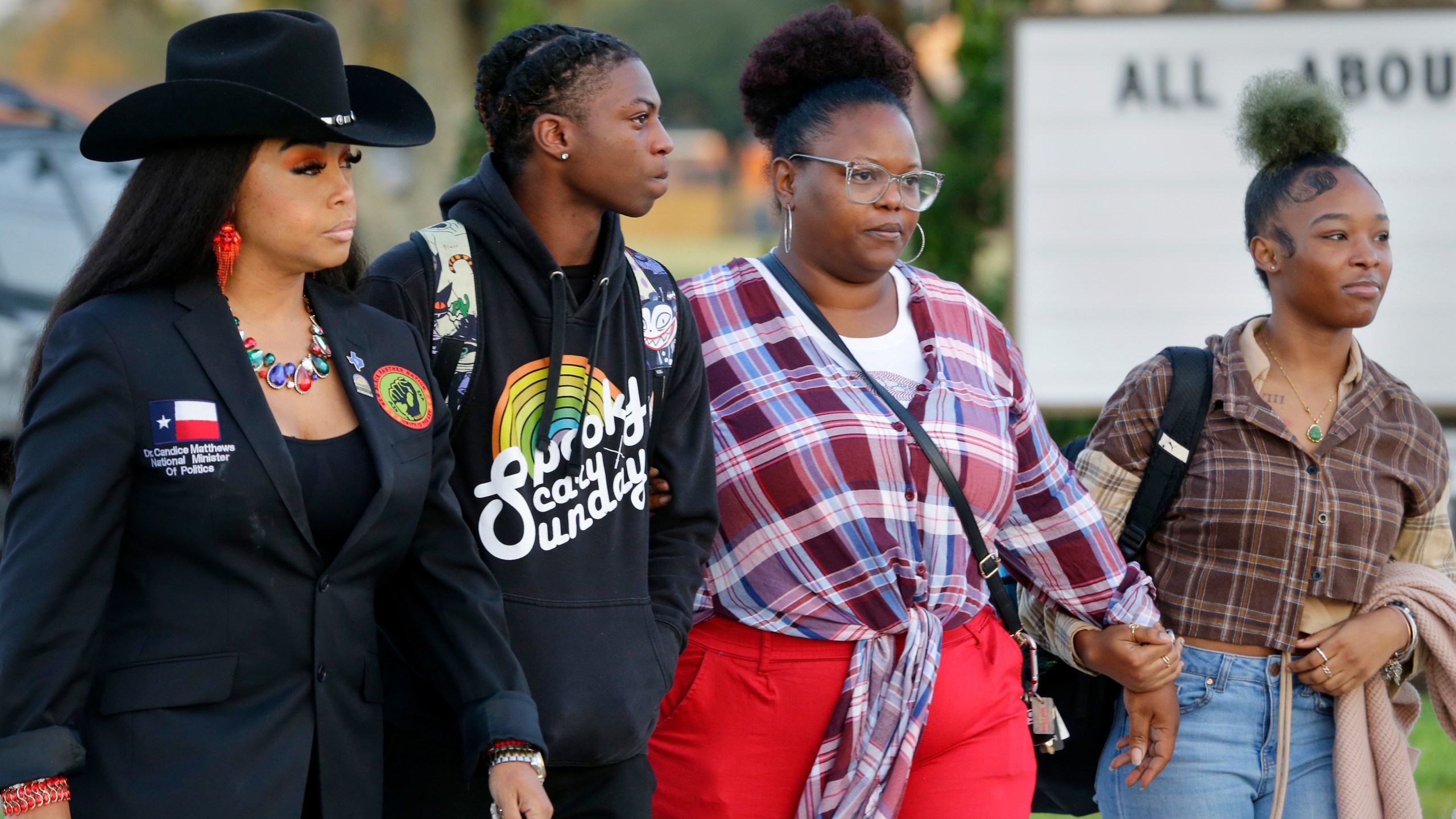 Candice Matthews, left, National minister of politics for the New Black Panther Nation; Darryl George, center left, a 17-year-old junior, and his mother Darresha George, center right, and a unidentified female, right, begin their walk across the street to go into Barbers Hill High School after Darryl served a 5-day in-school suspension for not cutting his hair Monday, Sept. 18, 2023, in Mont Belvieu. (AP Photo/Michael Wyke)