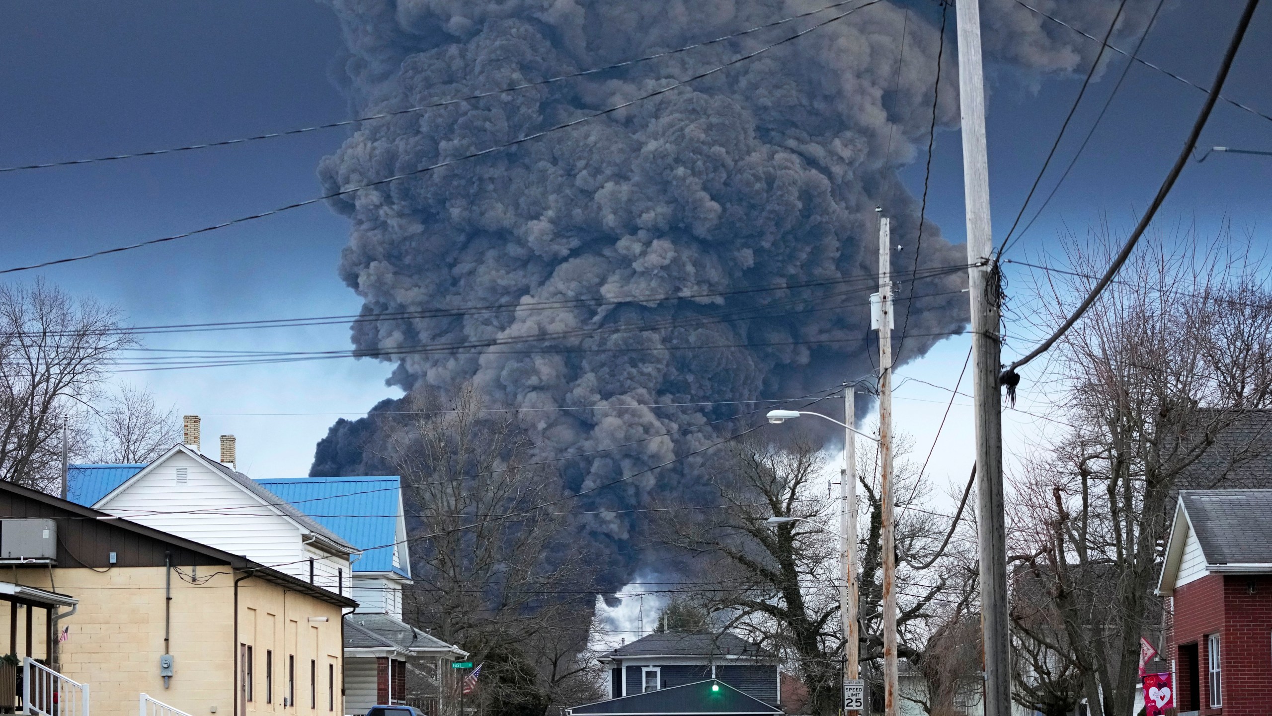 A black plume rises over East Palestine, Ohio, as a result of a controlled detonation of a portion of the derailed Norfolk Southern trains.