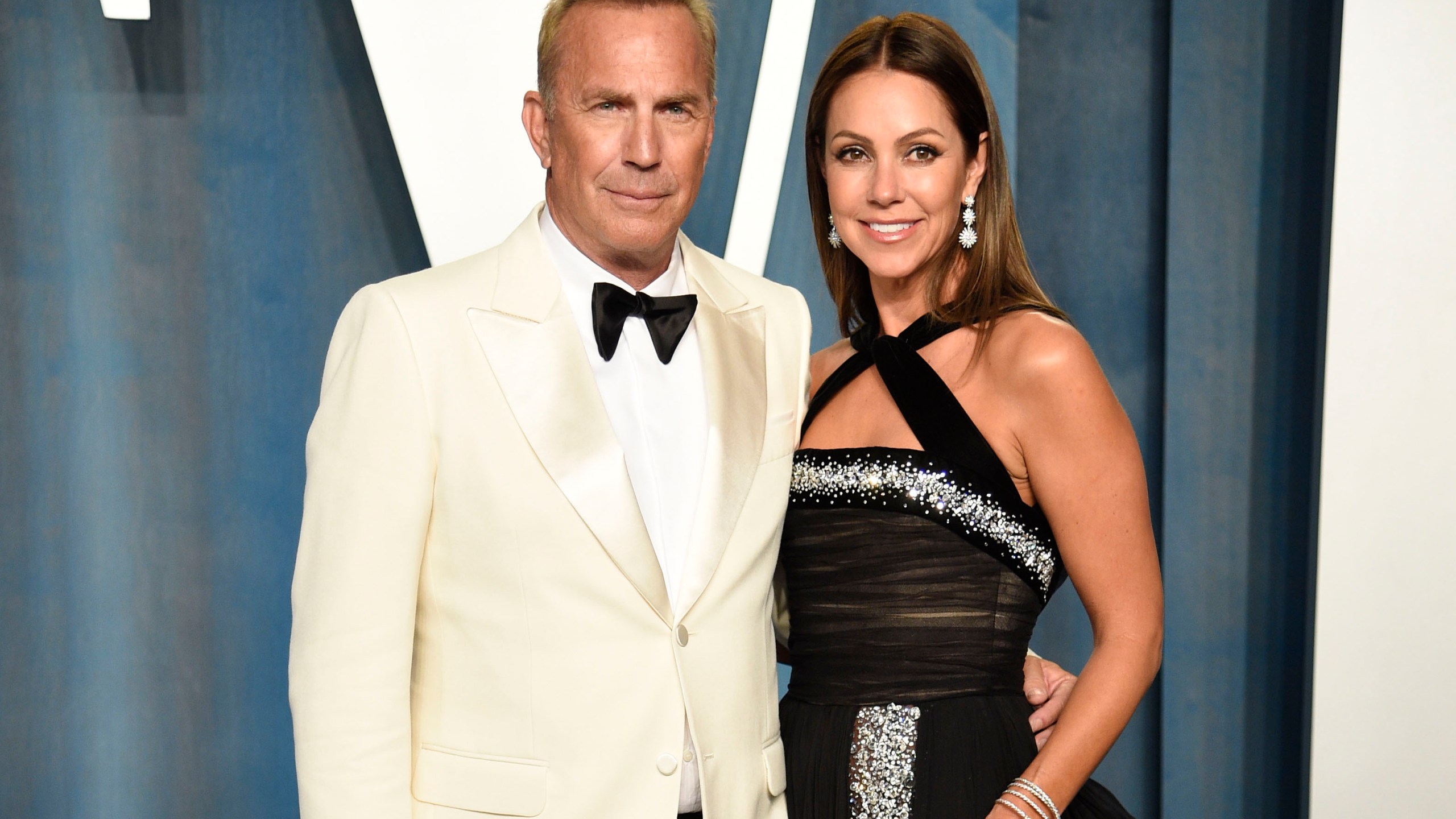 FILE - Kevin Costner, left, and Christine Baumgartner arrive at the Vanity Fair Oscar Party on March 27, 2022, in Beverly Hills, Calif. Costner and Baumgartner have reached a settlement in their divorce. The couple said in a joint statement that they have come to an amicable resolution to all the issues surrounding their split. (Photo by Evan Agostini/Invision/AP, File)