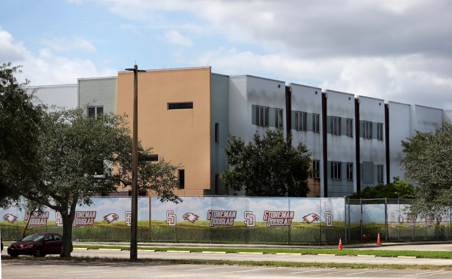 FILE - The 1200 building at Marjory Stoneman Douglas High School in Parkland, Fla., is seen, Oct. 20, 2021. The school building where 14 students and three staff members were fatally shot in a 2018 massacre is set to be demolished next summer, officials announced Thursday, Sept. 21, 2023. The demolition of Marjory Stoneman Douglas High School’s 1200 building, which has remained closed and locked behind a fence since the shooting, is scheduled to take place immediately following the conclusion of the school year. (Carline Jean/South Florida Sun-Sentinel via AP, File)