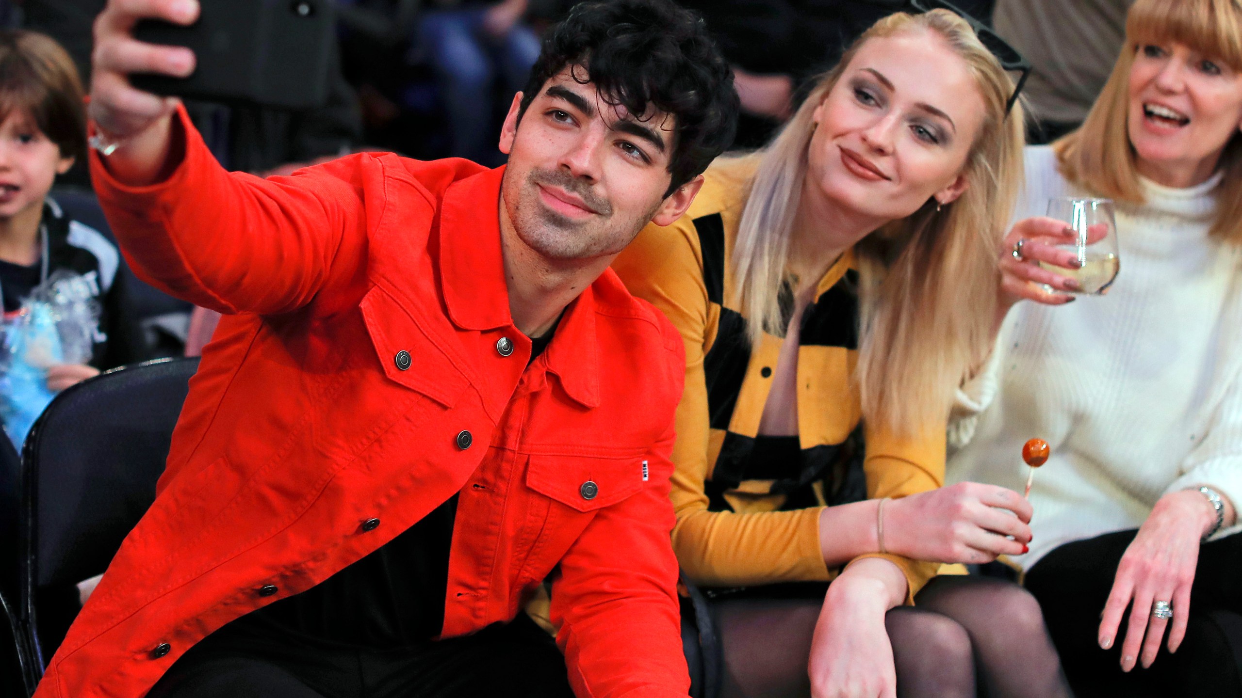 FILE Musician Joe Jonas, left, takes a selfie with actress Sophie Turner during a break in play of an NBA basketball game between the New York Knicks and the Sacramento Kings, Saturday, March 9, 2019, in New York. Turner sued her estranged pop star husband Jonas on Thursday, Sept. 21, 2023, to force him to turn over the passports of the couple's two young daughters so she can take them to England. (AP Photo/Julie Jacobson, File)