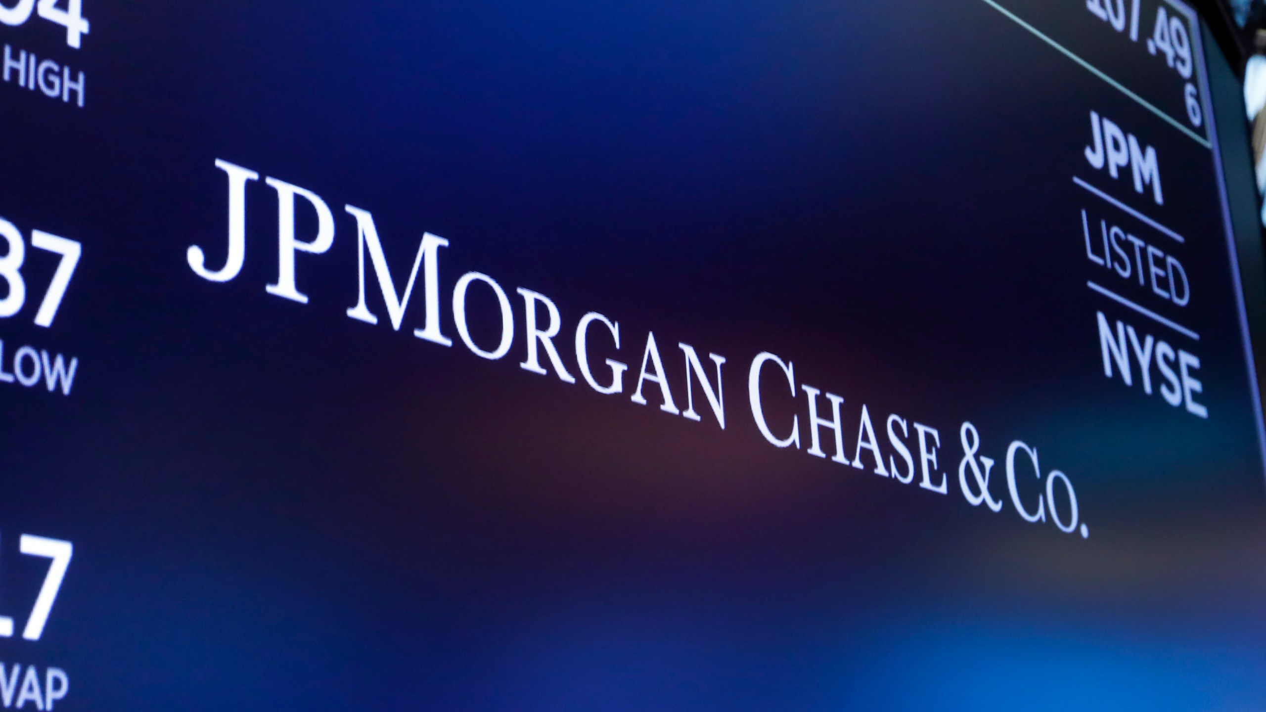 FILE - The logo for JPMorgan Chase & Co. appears above a trading post on the floor of the New York Stock Exchange in New York, Aug. 16, 2019. Chase UK, JP Morgan’s British digital bank, said Tuesday, Sept. 26, 2023, that it will bar customers from making cryptocurrency transactions starting next month — citing an uptick in scams and fraud. (AP Photo/Richard Drew, File)