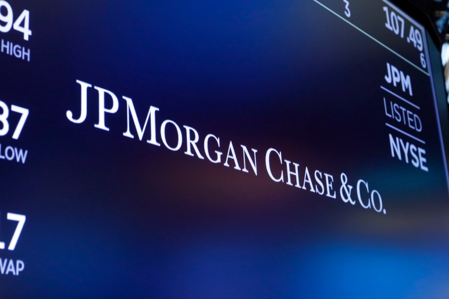 FILE - The logo for JPMorgan Chase & Co. appears above a trading post on the floor of the New York Stock Exchange in New York, Aug. 16, 2019. Chase UK, JP Morgan’s British digital bank, said Tuesday, Sept. 26, 2023, that it will bar customers from making cryptocurrency transactions starting next month — citing an uptick in scams and fraud. (AP Photo/Richard Drew, File)