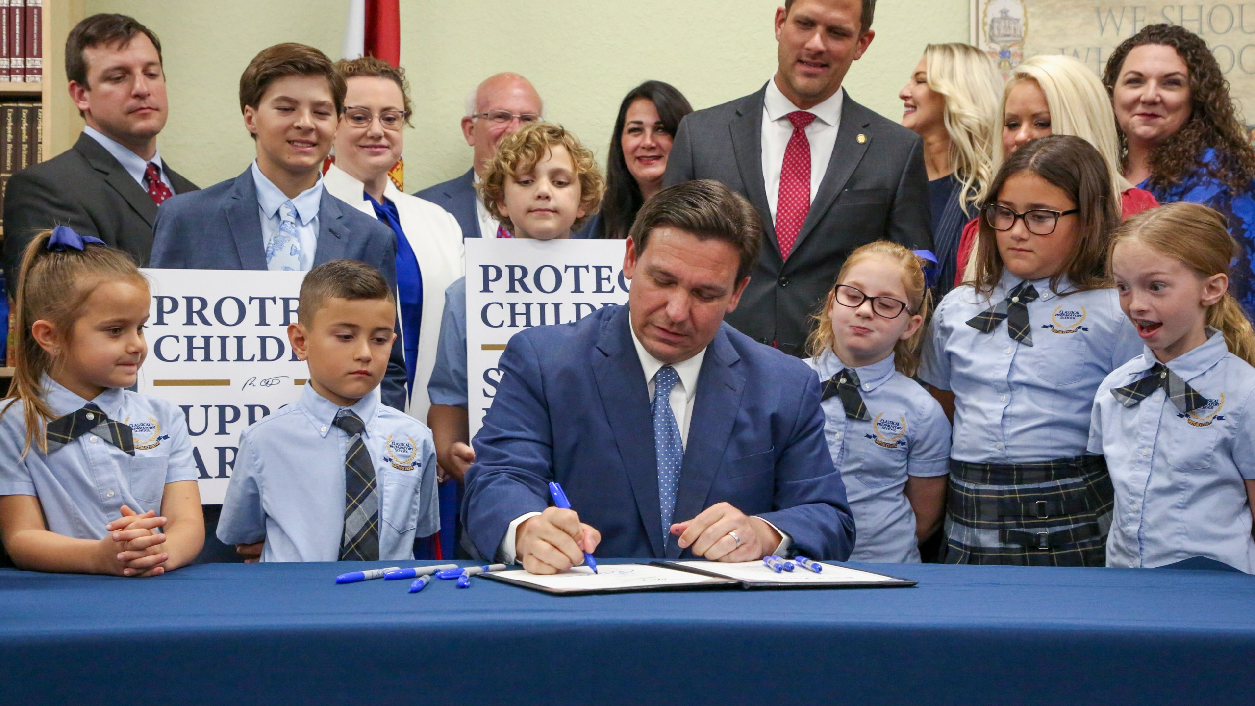 FILE - Florida Gov. Ron DeSantis signs the Parental Rights in Education bill at Classical Preparatory school, March 28, 2022, in Shady Hills, Fla. Top officials at a Florida school district ordered the removal of all books and material containing LBGTQ+ characters and themes from classrooms and campus libraries, saying that was needed to conform to a state law backed by DeSantis that critics have dubbed “Don't Say Gay,” according to a district memo obtained under a public information request by the Florida Freedom to Read Project. The nonprofit group, which opposes the law, provided the memo to The Associated Press on Wednesday, Sept. 27, 2023. (Douglas R. Clifford/Tampa Bay Times via AP, File)