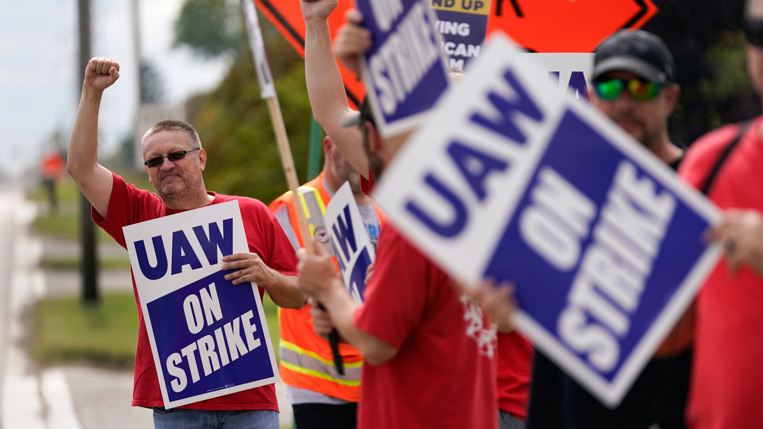 United Auto Workers member Mariusz Mirek holds a picket sign near a General Motors Assembly Plant in Delta Township, Mich., Friday, Sept. 29, 2023. The United Auto Workers union expanded its two-week strikes against Detroit automakers Friday, adding 7,000 workers at a Ford plant in Chicago and a General Motors assembly factory near Lansing, Michigan. (AP Photo/Paul Sancya)