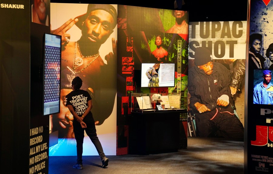 FILE - A visitor observes a display of late hip hop artist Tupac Shakur during the press preview day for the "Tupac Shakur. Wake Me When I'm Free" exhibition, Thursday, Jan. 20, 2022, at The Canvas at L.A. Live in Los Angeles. The unsolved killing of Shakur has taken a major turn. Duane “Keffe D” Davis was arrested Friday morning, although the exact charge or charges were not immediately clear, according to two officials with first-hand knowledge of the arrest. The renewed activity comes nearly 30 years after Shakur was gunned down on Sept. 7, 1996. (AP Photo/Chris Pizzello, File)