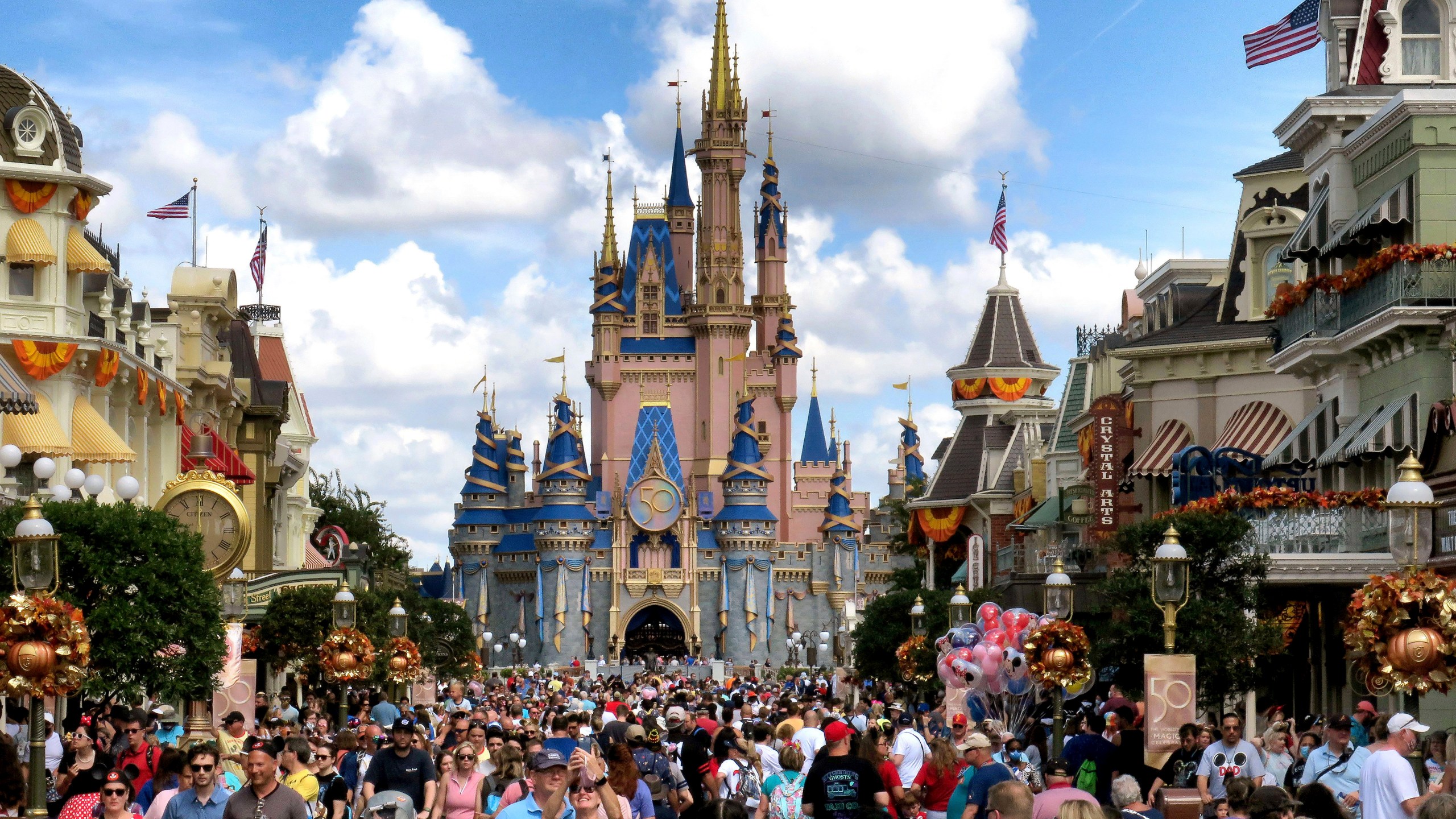 FILE - Crowds fill Main Street USA in front of Cinderella Castle at the Magic Kingdom on the 50th anniversary of Walt Disney World, in Lake Buena Vista, Fla., on Oct. 1, 2021. Facing backlash, Walt Disney World’s governing district will pay a stipend to employees whose free passes and discounts to the theme park resort were eliminated under a policy made by a new district administrator and board members who are allies of Florida Gov. Ron DeSantis. (Joe Burbank/Orlando Sentinel via AP, File)