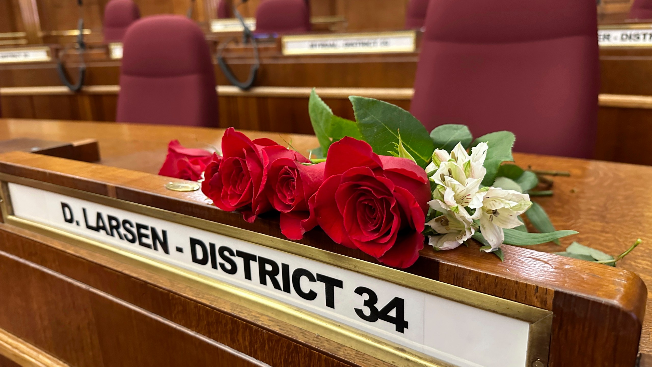 Roses rest on the Senate desk of late North Dakota Republican state Sen. Doug Larsen, at the state Capitol Monday, Oct. 2, 2023, in Bismarck, N.D. Larsen, his wife Amy, and their two young children died Sunday in a plane crash near Moab, Utah. Larsen was first elected to the state Senate in 2020. (AP Photo/Jack Dura)