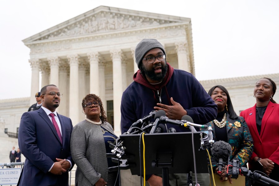 FILE - Evan Milligan, center, plaintiff in Merrill v. Milligan, an Alabama redistricting case speaks with reporters following oral arguments at the Supreme Court in Washington, Oct. 4, 2022. The plaintiffs in voting rights cases in Alabama and Louisiana hoped they would be looking at new maps with additional districts where Black voters might have the opportunity to choose the congress member of their choice. Instead, they are facing continuing fights, including one where Alabama has taken a seemingly oppositional stance to the U.S. Supreme Court's most recent voting rights ruling. (AP Photo/Patrick Semansky, File)