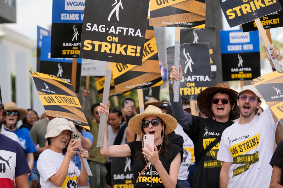 Picketers carry signs on the picket line outside Netflix on Wednesday, Sept. 27, 2023, in Los Angeles. Hollywood's writers strike was declared over Tuesday night when board members from their union approved a contract agreement with studios, bringing the industry at least partly back from a historic halt in production. The actors strike continues in their bid to get better pay and working conditions. (AP Photo/Chris Pizzello)