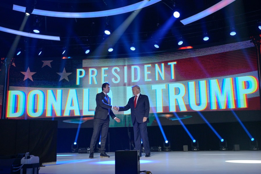 FILE - Former President Donald Trump, right, shakes hands with Turning Point CEO Charlie Kirk before speaking during the Turning Point USA Student Action Summit, July 23, 2022, in Tampa, Fla. The nonprofit rocketed to prominence by latching on to Trump’s 2016 campaign and has raised roughly a quarter-billion dollars since, much of it spent cultivating conservative influencers and hosting glitzy events. The organization also enriched Kirk and his allies, according to an Associated Press review of public records. (AP Photo/Phelan M. Ebenhack, File)