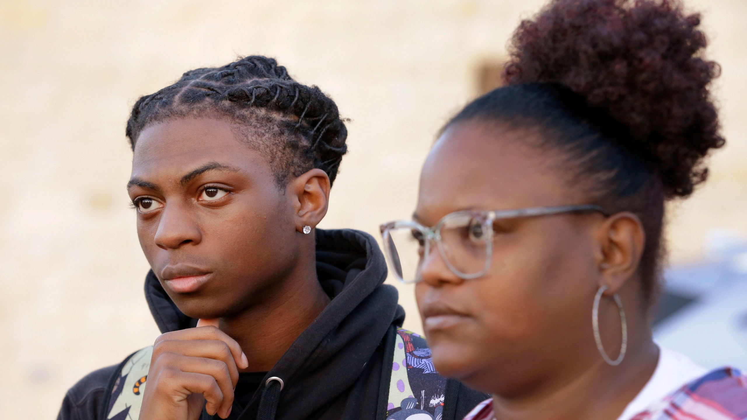 FILE - Darryl George, left, an 18 year-old junior, and his mother Darresha George, right, talk with reporters before walking into Barbers Hill High School after he served an in-school suspension for not cutting his hair on Sept. 18, 2023, in Mont Belvieu, Texas. Darryl George will be sent to EPIC, an alternative school program, from Oct. 12 through Nov. 29 for “failure to comply” with multiple campus and classroom regulations, the principal said in a Wednesday, Oct. 11, letter provided to The Associated Press by the family. (AP Photo/Michael Wyke, File)