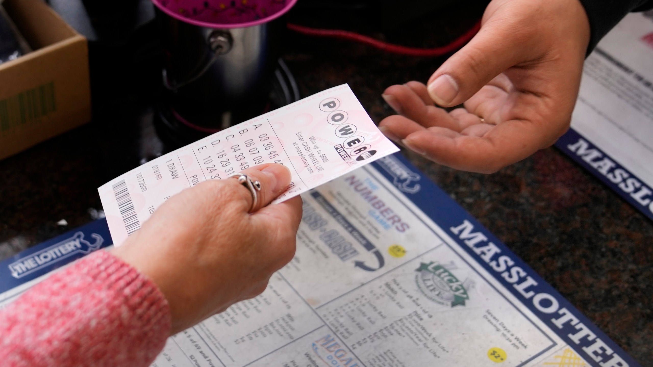 A customer purchases five Powerball tickets at a lottery agent, Tuesday, Oct. 10, 2023, in Haverhill, Mass. After 35 straight drawings without a big winner, Powerball players will have a shot Wednesday at a near-record jackpot worth an estimated $1.73 billion. (AP Photo/Charles Krupa)